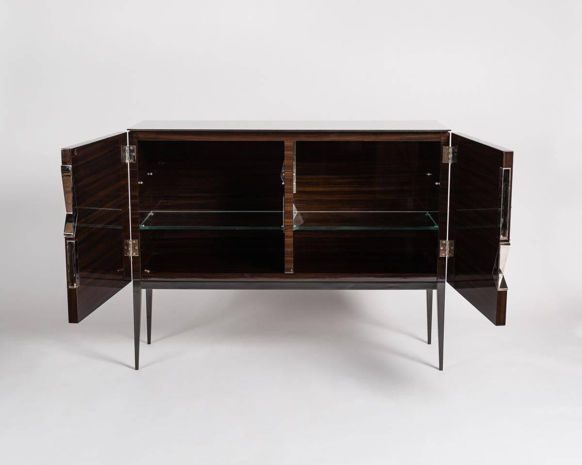 Giò is a double door cabinet of Royal Oak with a mirrored top and cast bronze, gun metal patinated legs. An homage to the Italian designer’s predecessor Gio Ponti, the cabinet possesses elements of this earlier artist’s aesthetic, which have been