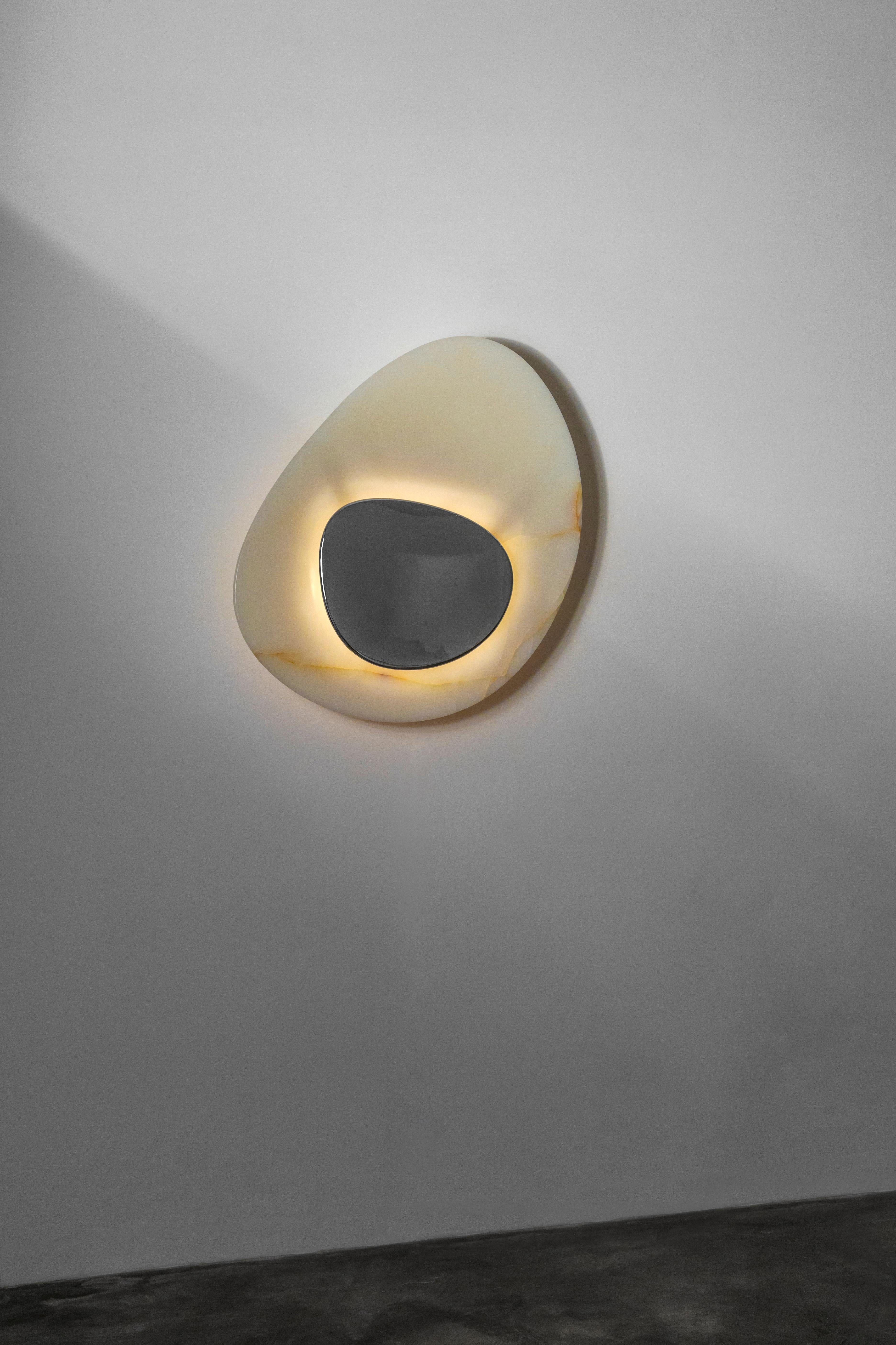 This piece, one of a limited edition of six, is made up of an oblong mirror set in a beautifully veined concave piece of onyx.