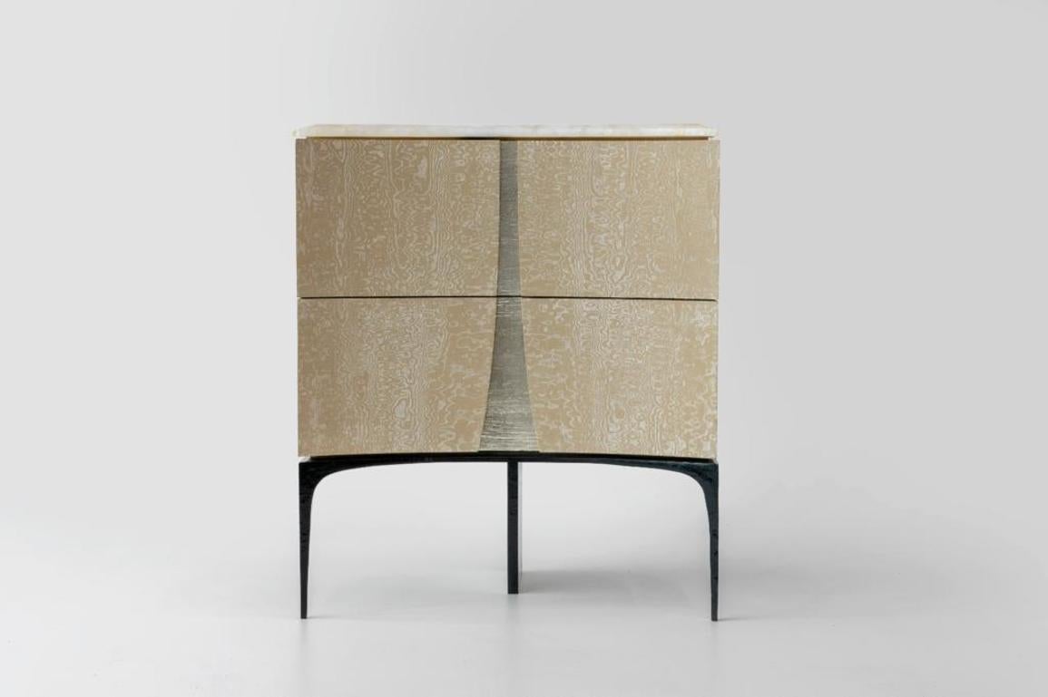 Achille Salvagni's beautiful bedside tables have sensually concave, double doors of clad in parchment, and are topped in onyx. Each rests on three legs, the central one of which is, itself, a visual blade of exquisitely polished bronze.