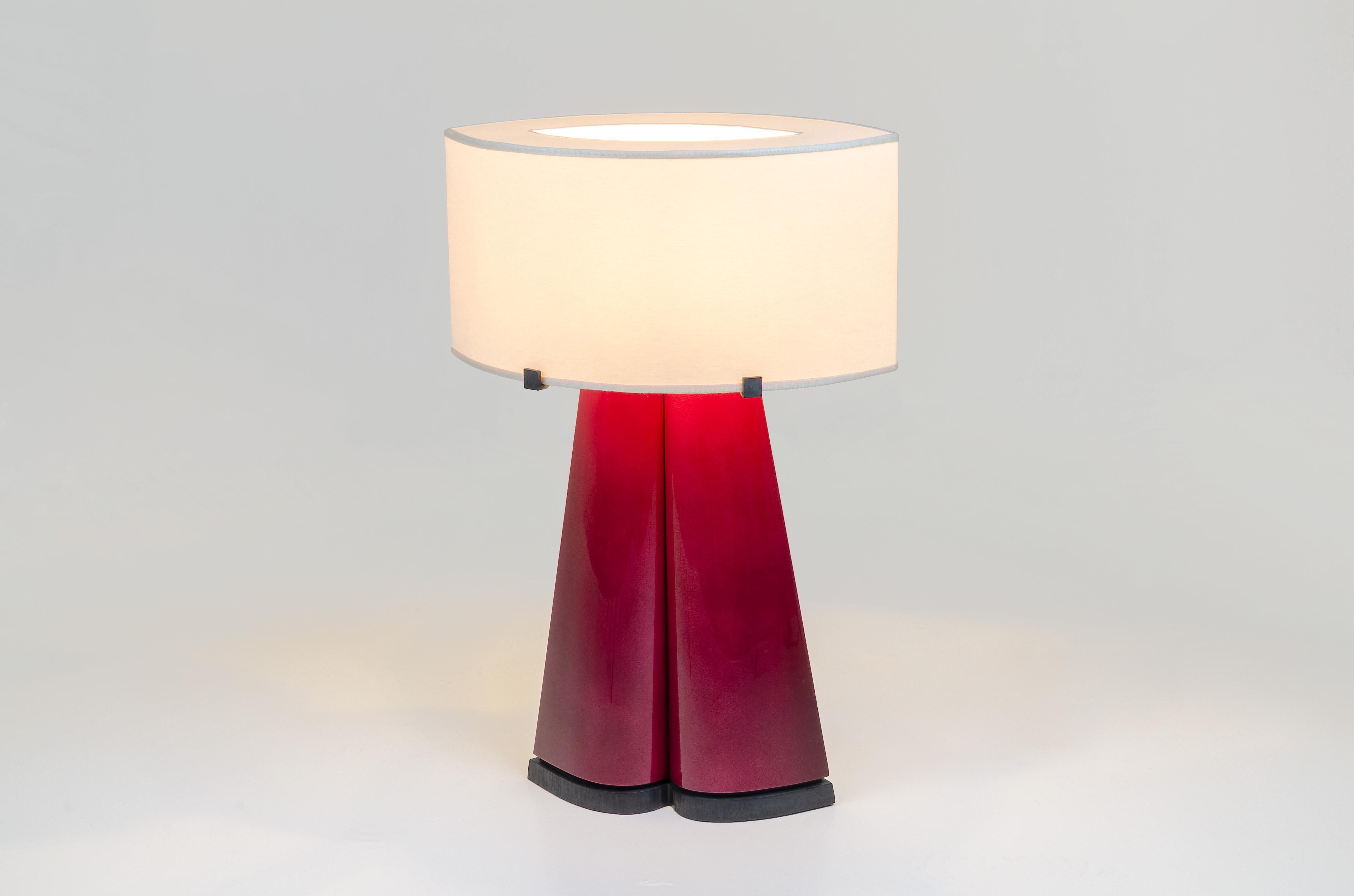 Achille Salvagni
Sotirio red
2019

This triangular table lamp made of burnished cast bronze is complimented by a handmade organic silk Shade. The body is finished in a rich red lacquered parchment which beautifully contrasts the softness of the