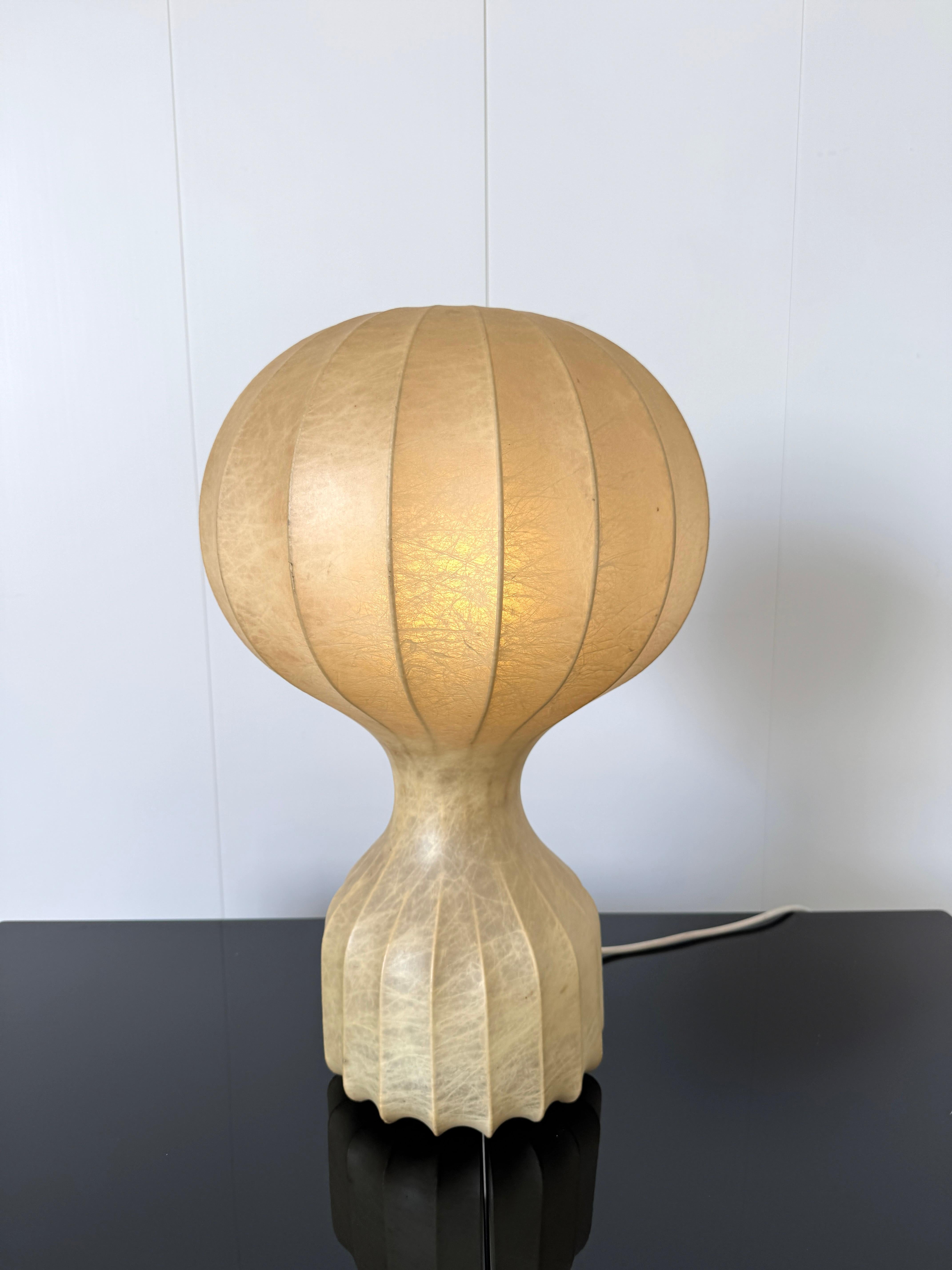 Struttura in acciaio con diffusore in cocoon.
Prod. Flos, Italia, 1962.

Costituito da un rivestimento in resina liquida spruzzata attorno a un’anima in metallo, il cocoon è materia che si trasforma in design. Dalle prime sperimentazioni degli anni