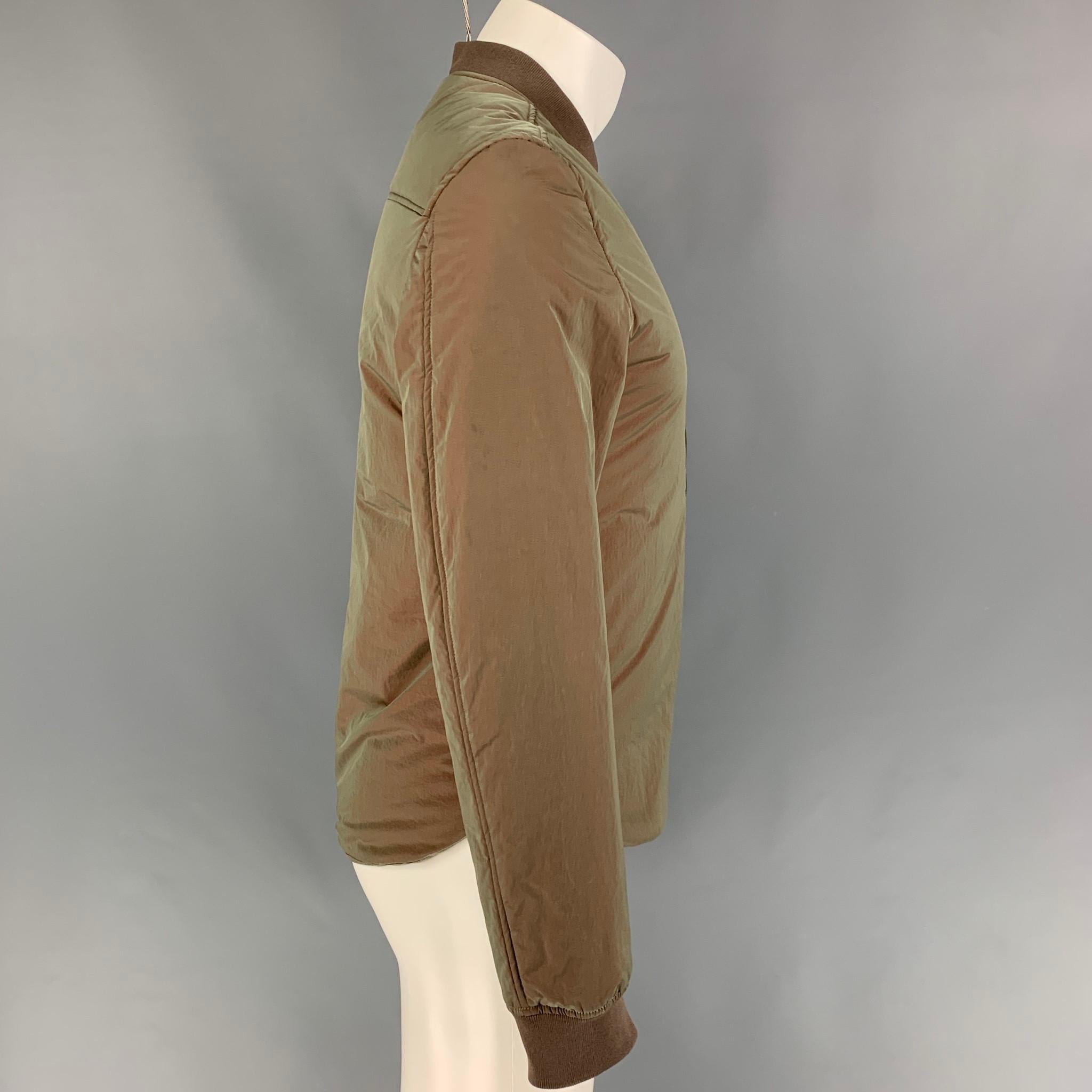 ACNE STUDIOS jacket comes in a olive green iridescent nylon featuring a bomber style, leather patch, ribbed hem, sleeve pocket detail, and a full zip up closure. Made in Romania. 

Very Good Pre-Owned Condition.
Marked: 44

Measurements:

Shoulder: