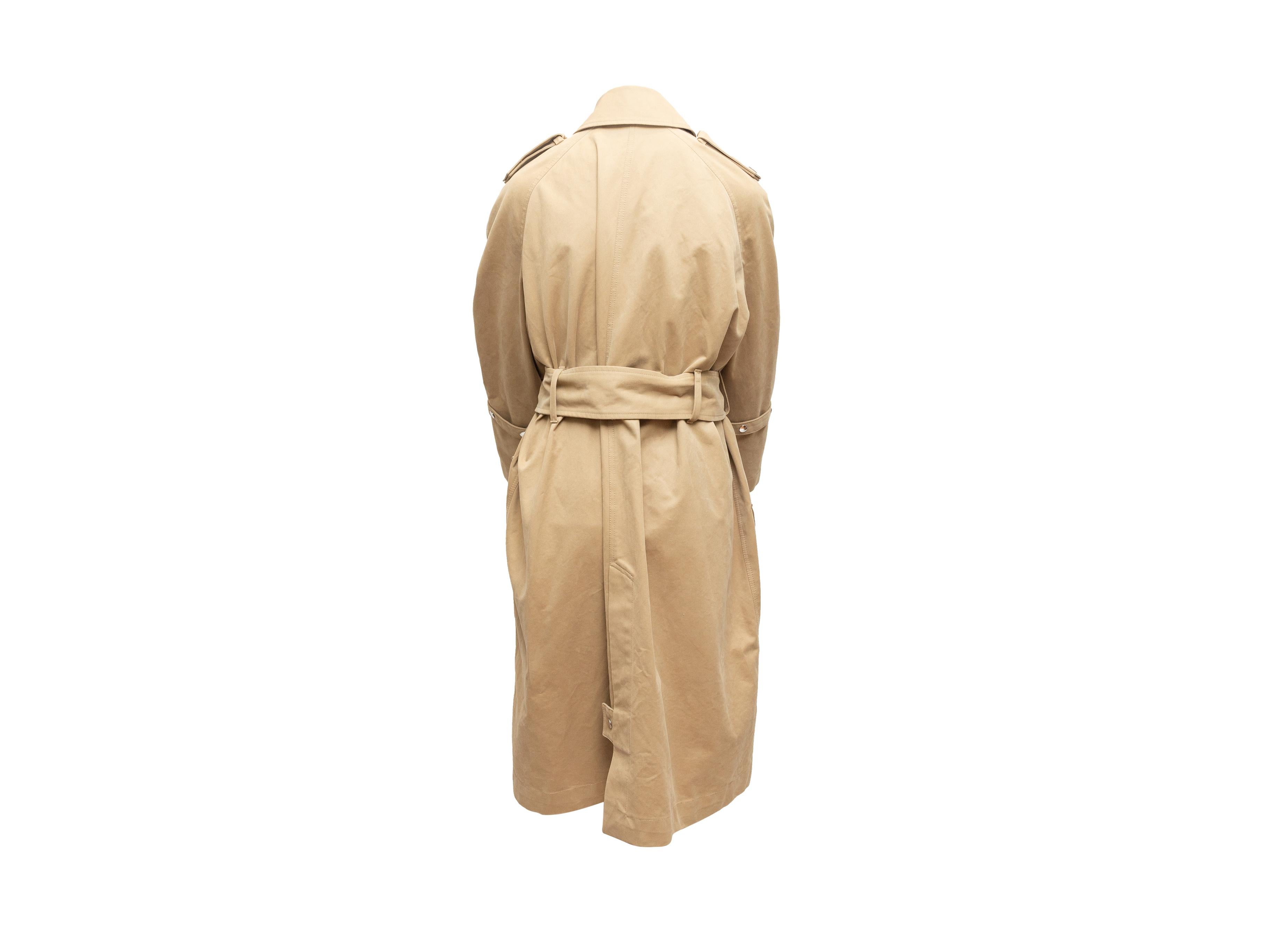 Product details: Tan double-breasted cotton trench coat by Acne Studios. Pointed collar. Sash belt at waist. Three hip pockets. Button closures at front. Designer size 36. 38