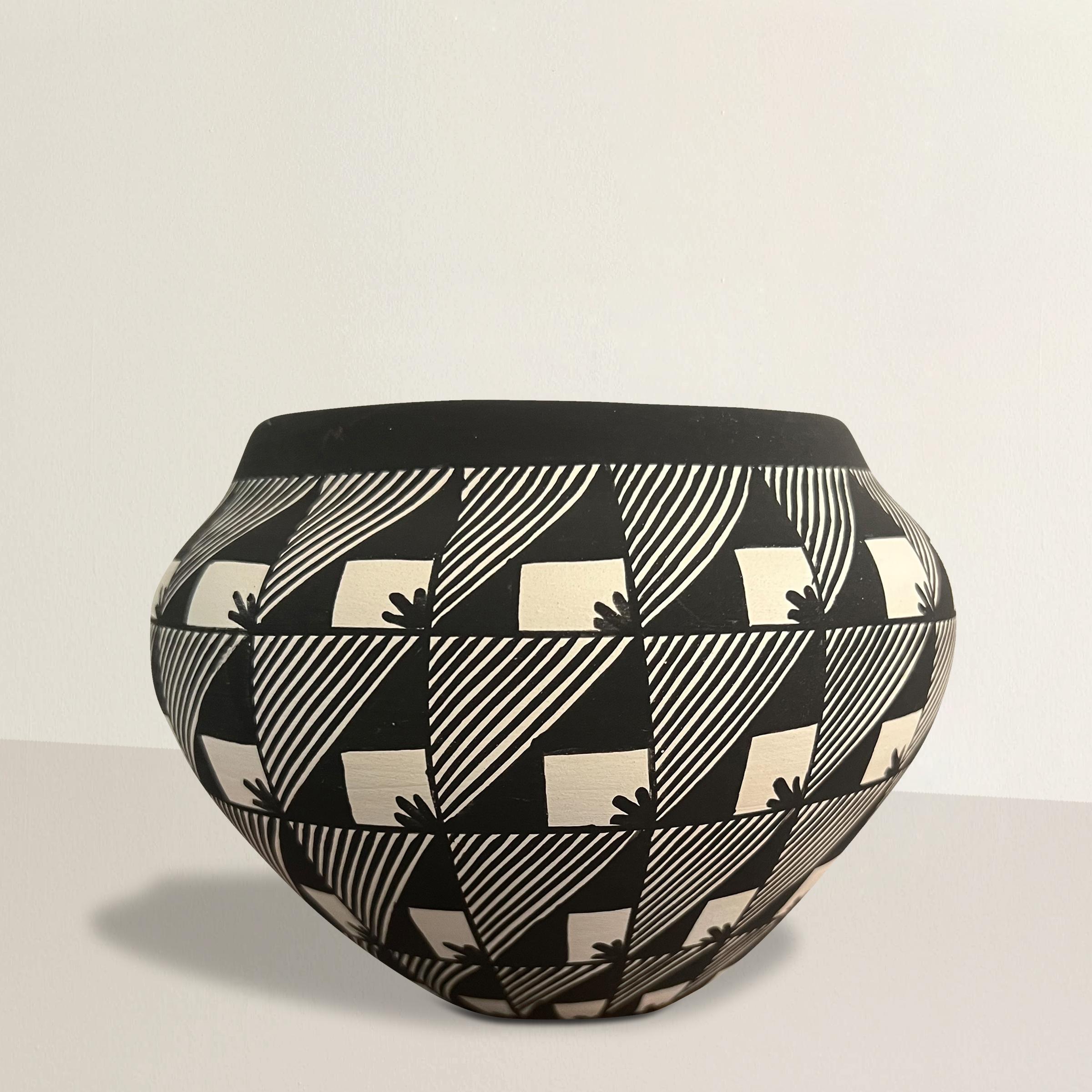 Questa ciotola in ceramica di Pueblo Acoma dell'inizio del XXI secolo, realizzata dalla rinomata maestra ceramista Virginia Victorino, esemplifica la precisione e la bellezza del design tradizionale di Acoma. Il motivo a griglia in bianco e nero