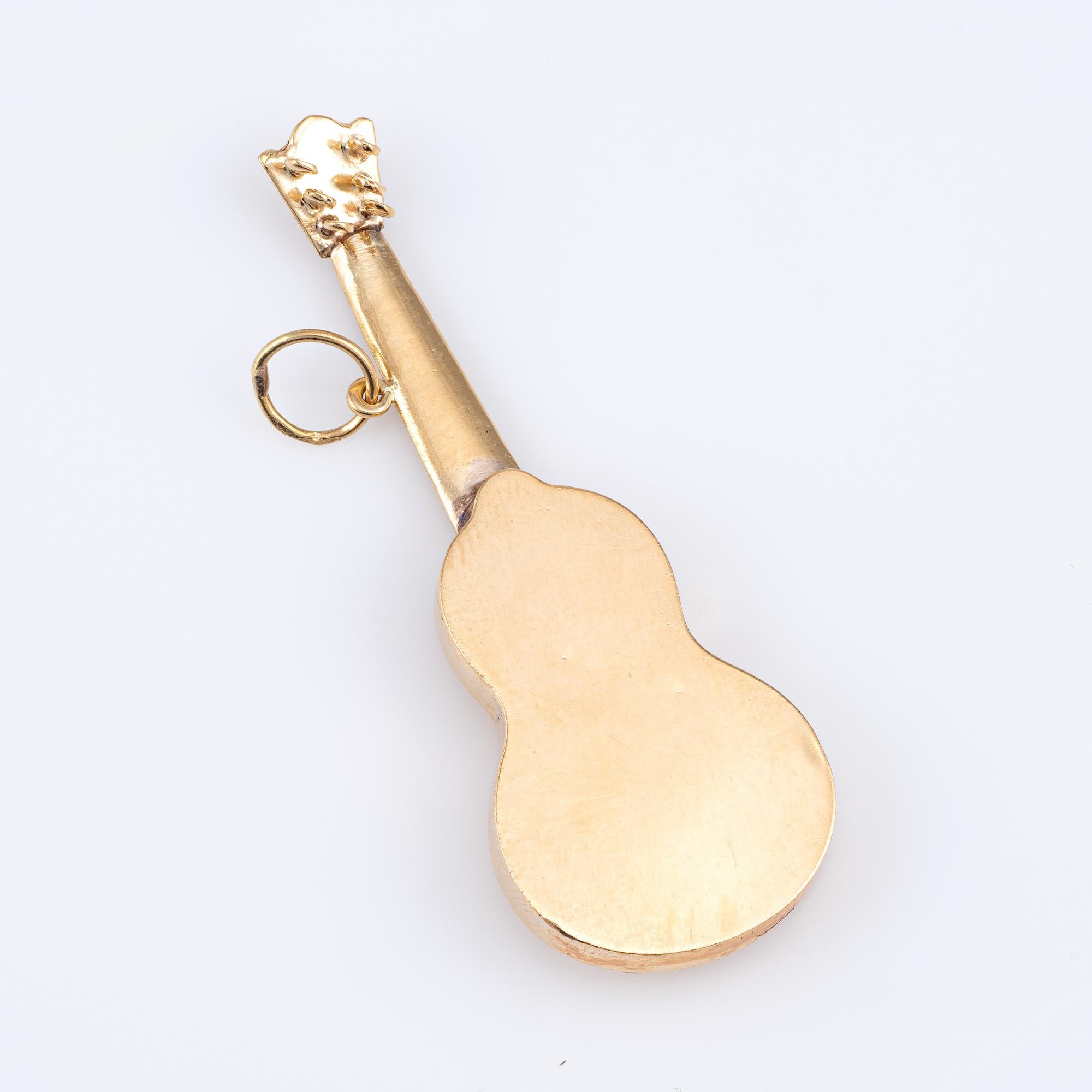 Finely detailed acoustic guitar pendant crafted in 18k yellow gold (circa 1970s).  

The nicely detailed pendant features three-dimensional detail that realistically depicts an acoustic guitar.    

The pendant is in very good condition. We have not