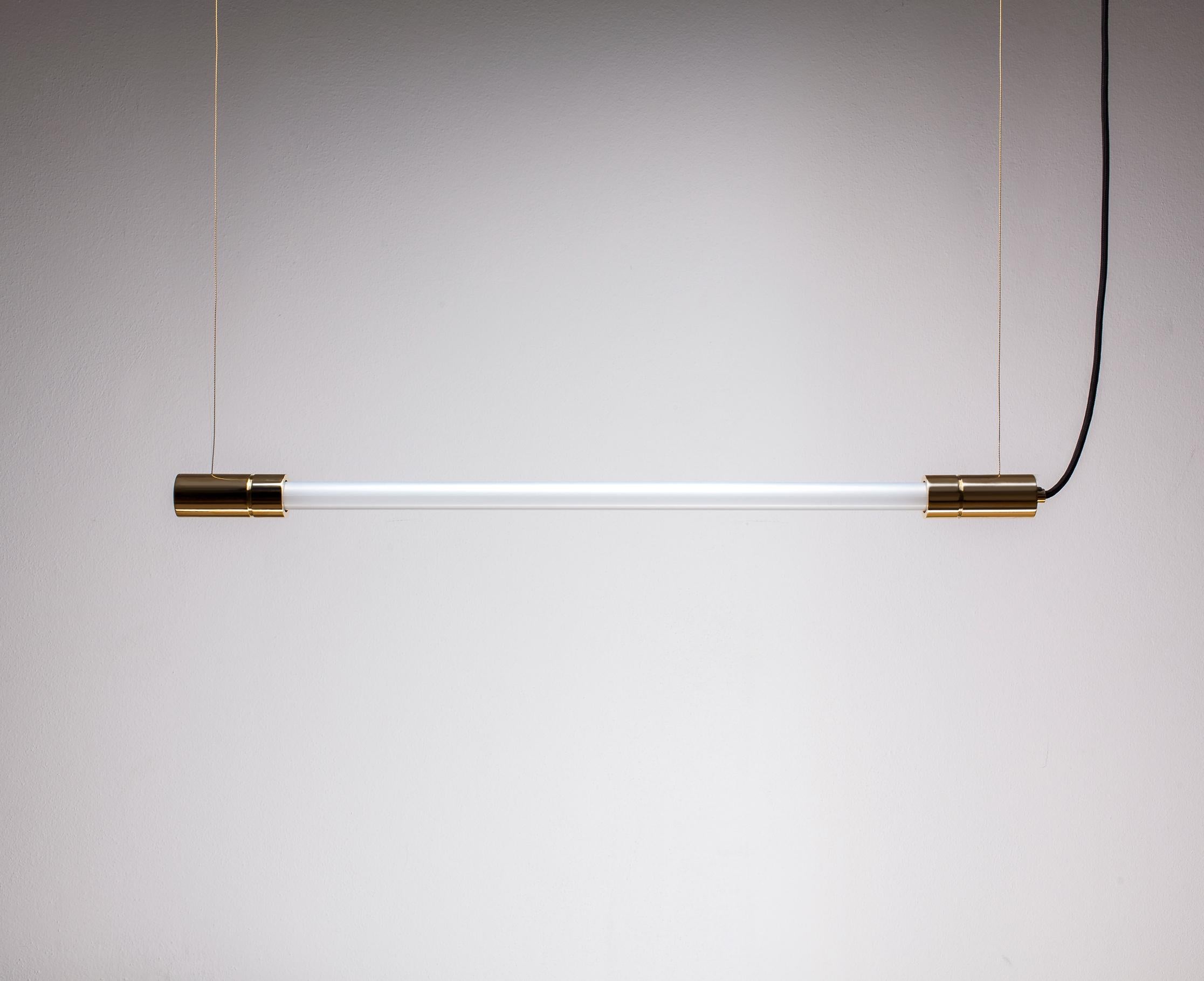 Acra solid brass suspended light by Lexavala.
Dimensions: D 4 x H 95 cm 
Materials: brass, glass.

Available in one shape of the socket but in two materials options. Different size means different lengths of the fluorescent lamp.

Hello! My