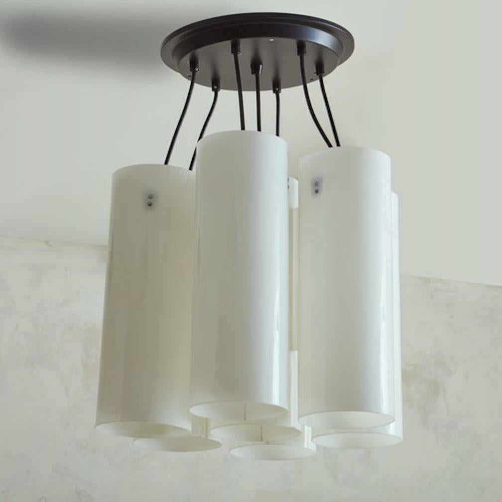 A vintage Italian chandelier featuring seven large white acrylic cylinder shades, which are suspended from an oversized black canopy. The outer shades are attached to the central shade. Unmarked. Sourced in Italy, 20th Century.

DIMENSIONS: 18.5