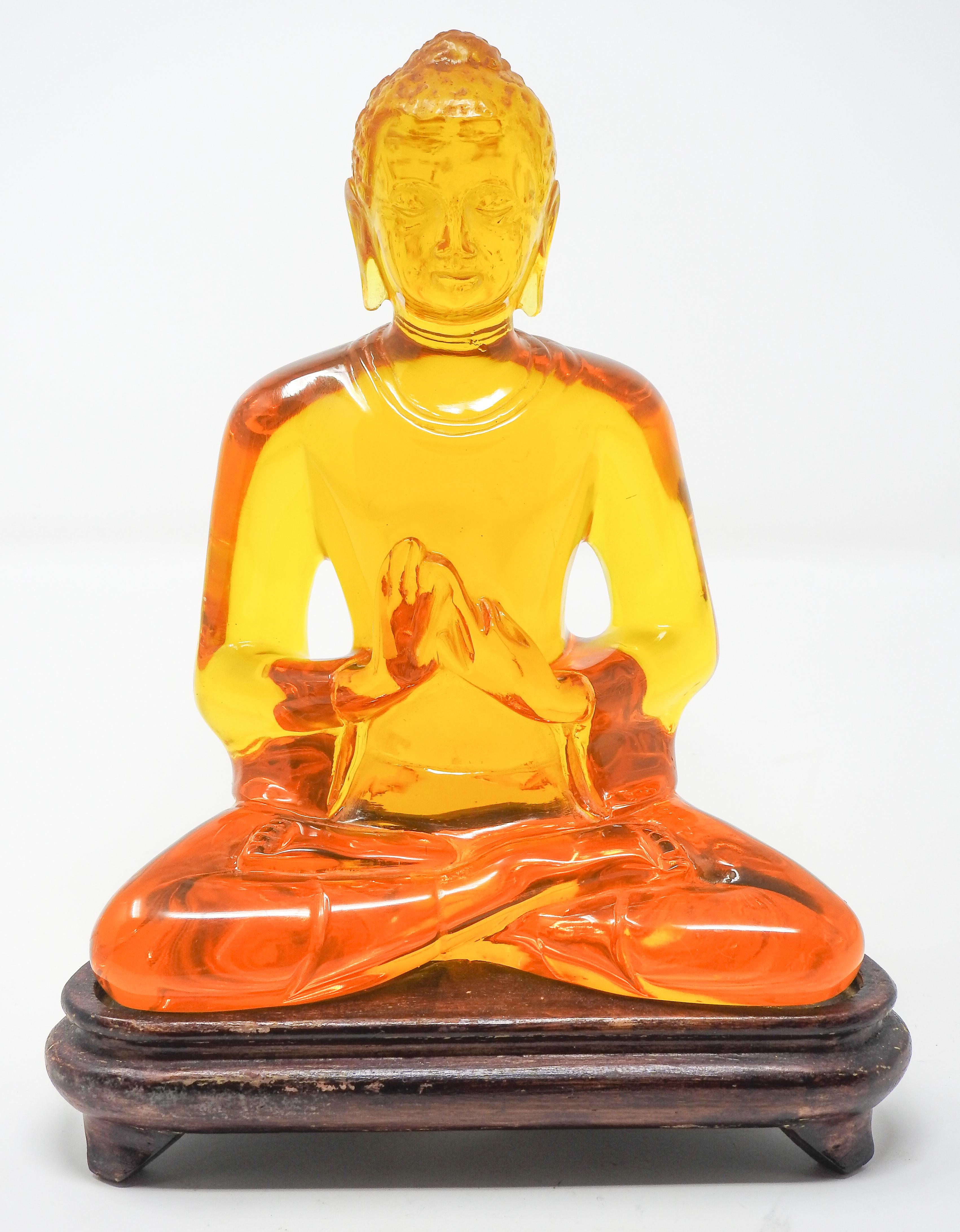 Offering this beautiful acrylic amber Buddha statue. The statue sits on a wooden base.