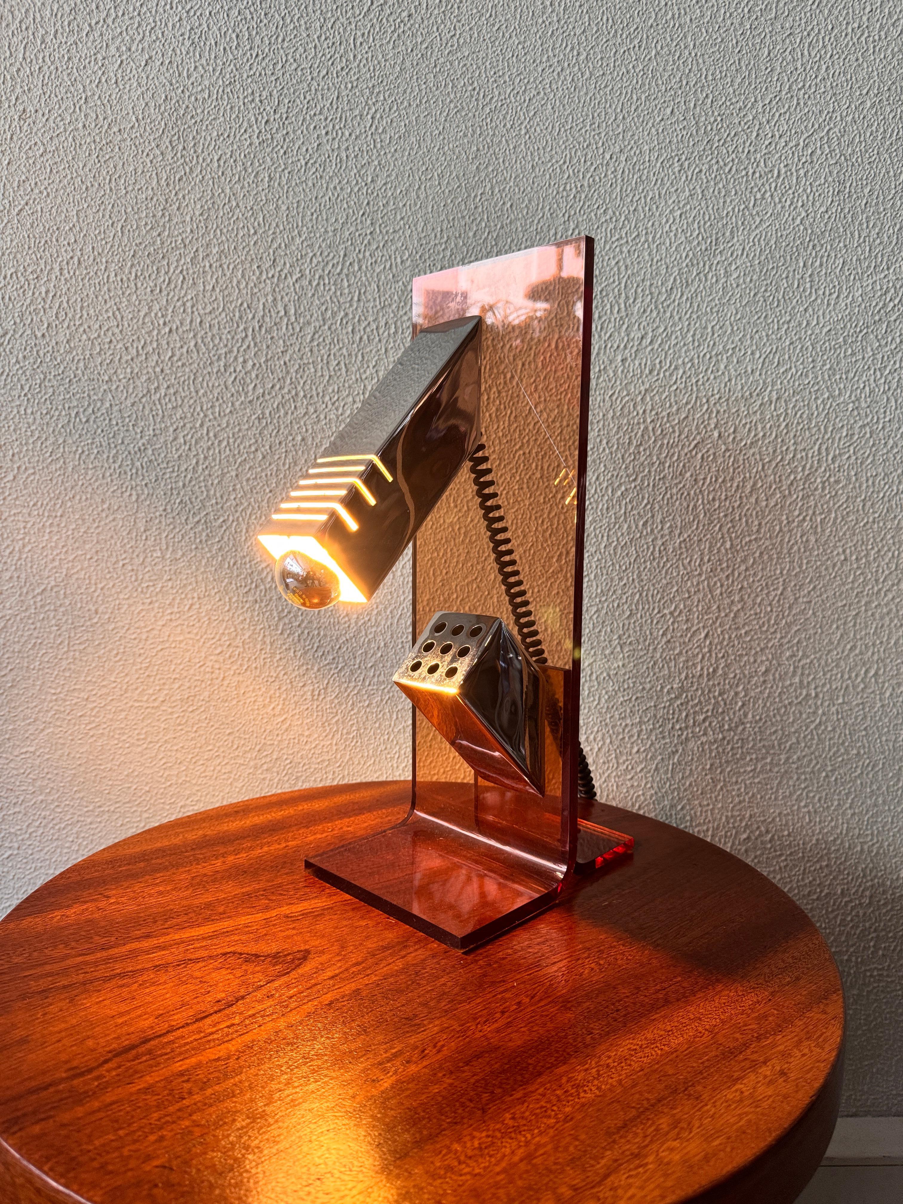 This sculptural table lamp was produced by Fase in Spain during the 1970s and captures the experimental spirit of the brand's design language in that era. A bold interplay of materials and geometry, the lamp features a thick bent sheet of