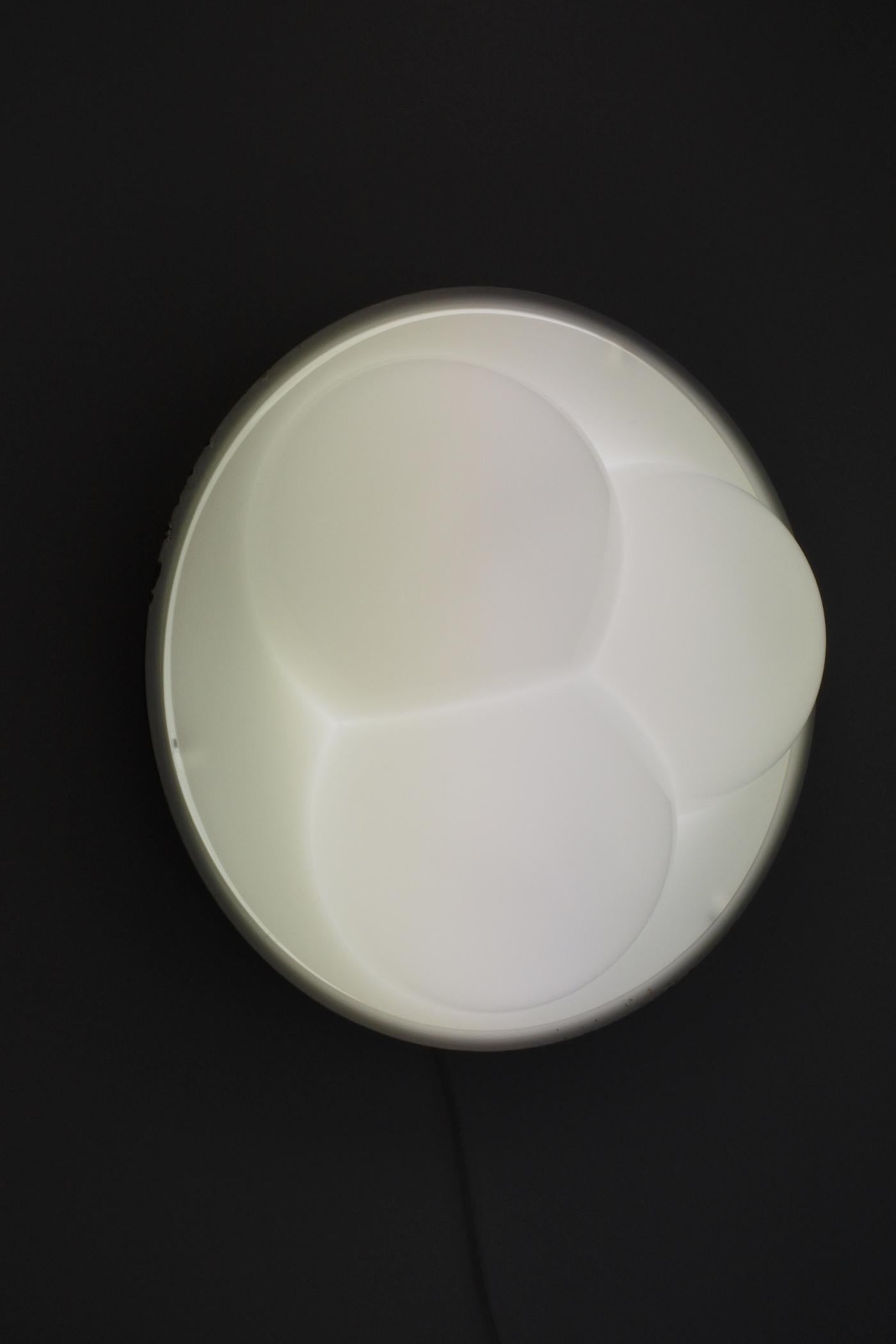 Lampe encastrée fabriquée par RAAK Holland dans les années 1970. 
Fabriqué en acrylique blanc avec une base en métal laqué.
La lampe abrite une ampoule néon ronde (incluse) mais peut être convertie pour accueillir une douille e27 ordinaire.
Elle