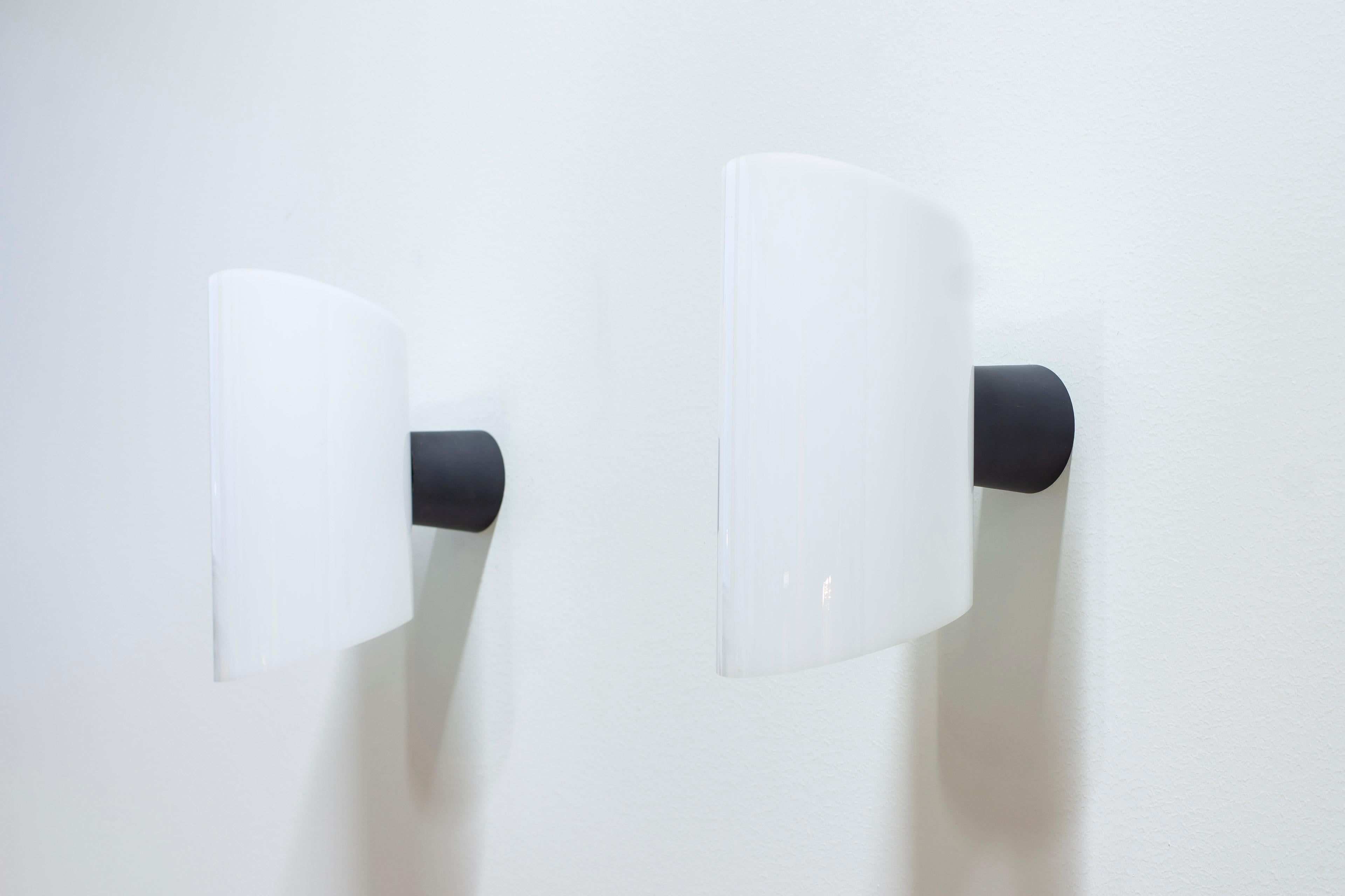 Rare wall lamps designed by Bo Råman. Produced in Sweden by ASEA during the early 1960s. Made from black lacquered metal and white acrylic. Very good condition with few signs of wear and light age related patina.



Price for the pair.



Designer: