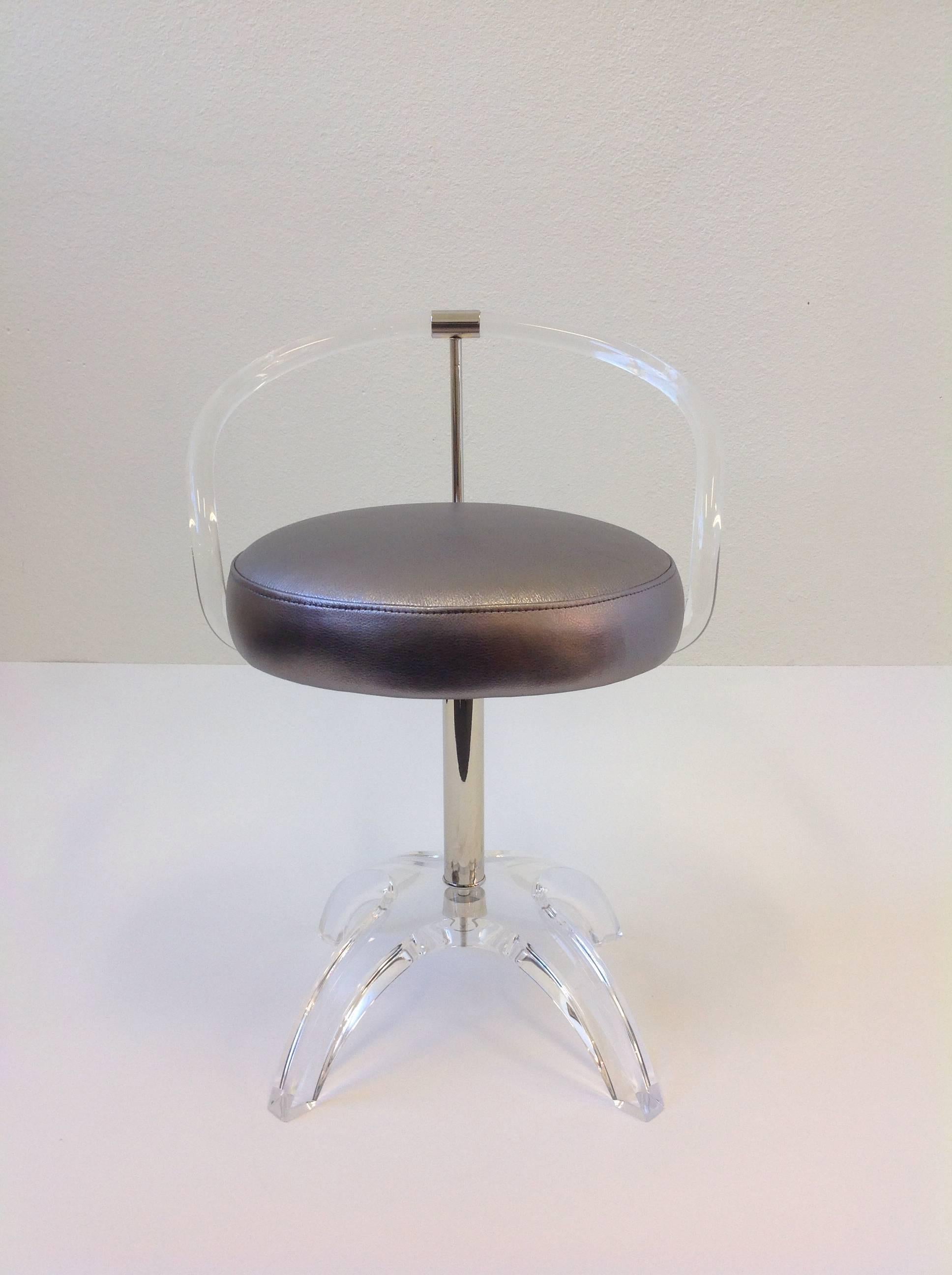 A glamorous clear acrylic and polished nickel with a metallic silver leather seat vanity stool. The stool Swivels 360 degrees. This was originally commissioned by Lucille Ball in 1965.
The stool has been newly restored. 

Dimension: 26