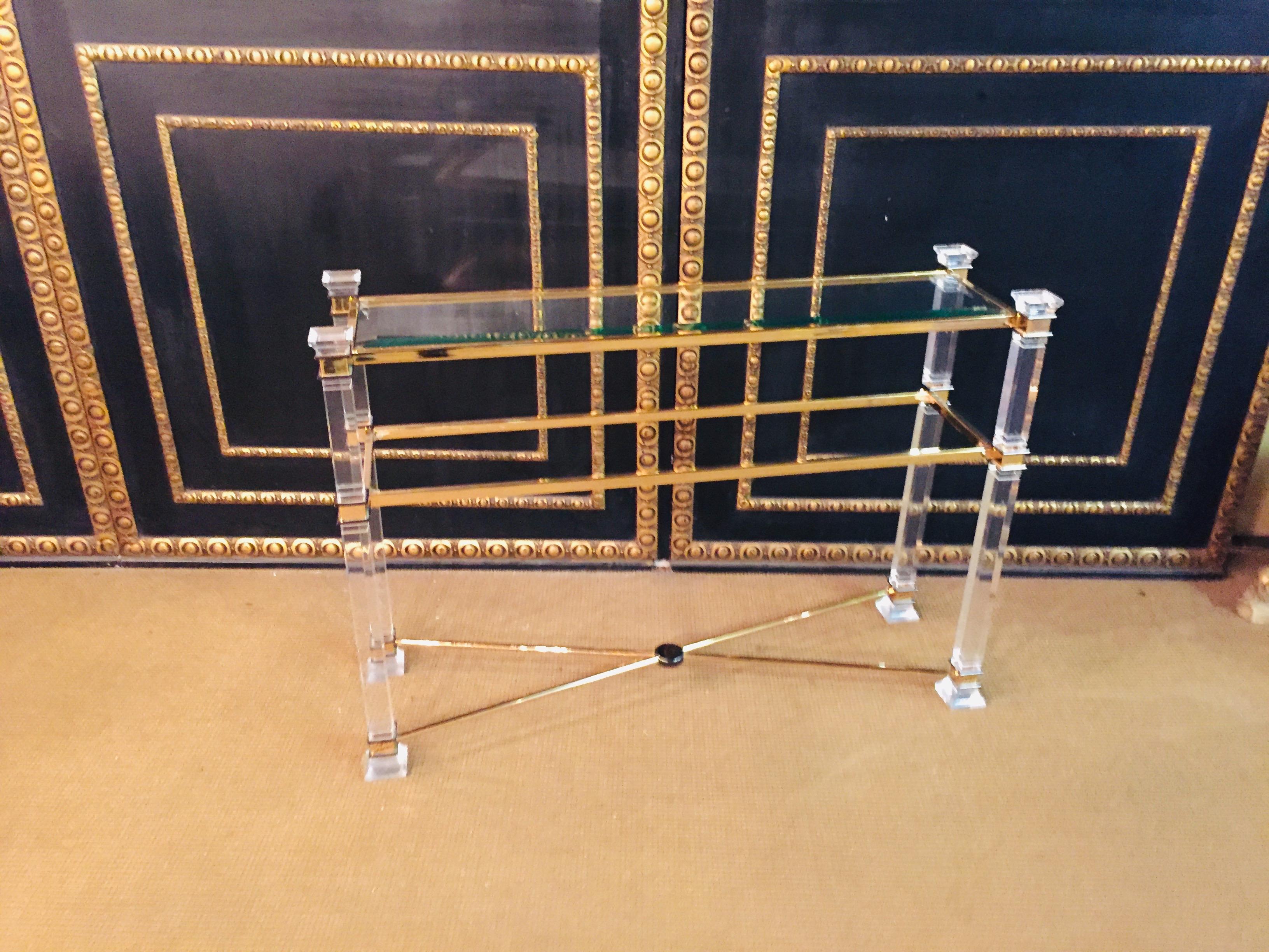 Acrylic console 2 glass plates on four rectangular columns decorated with brass.
2 brass struts trimmed at the bottom.