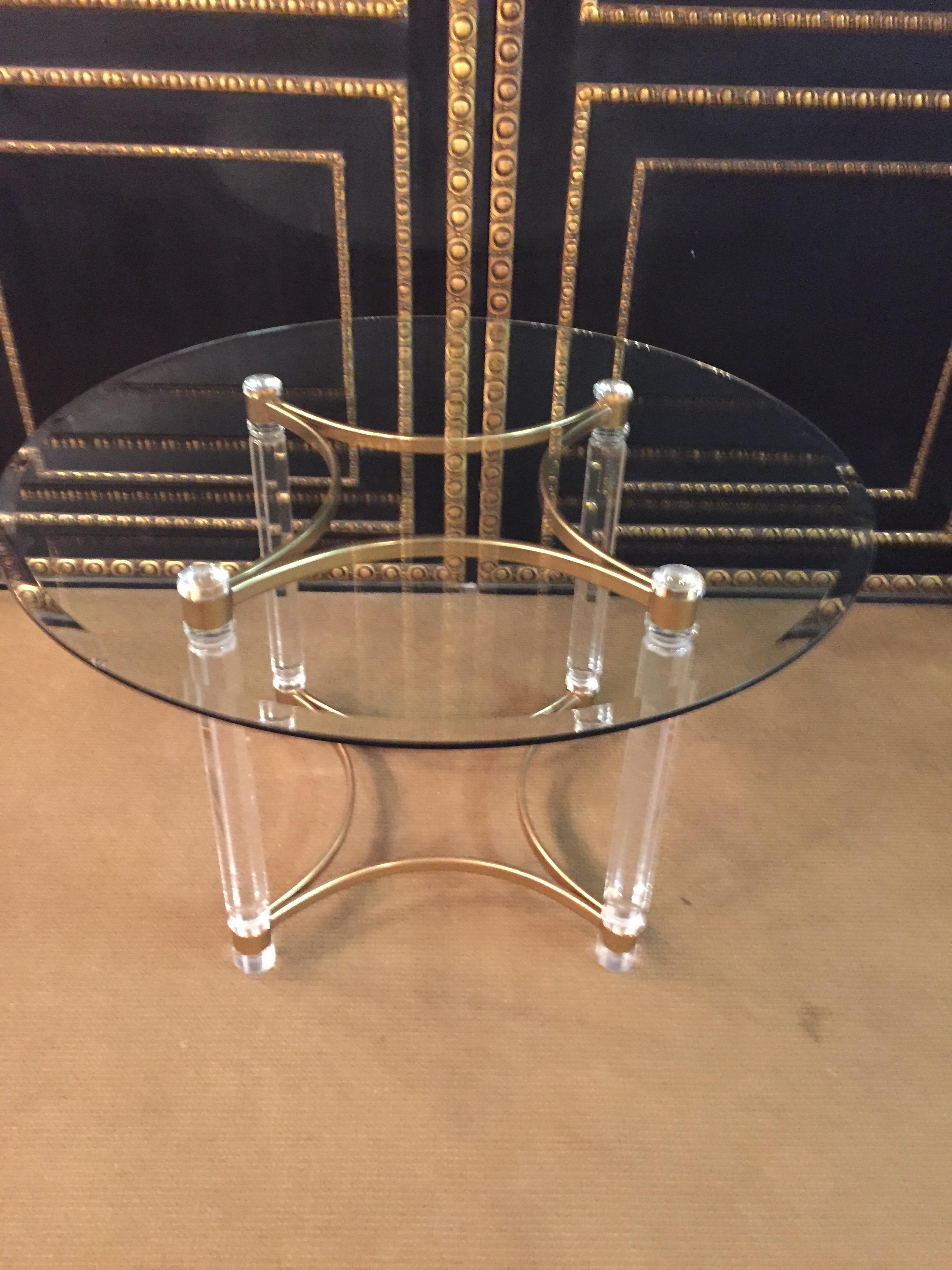 High quality acrylic dining table with acrylic columns legs,
the legs are connected at the bottom with a brass frame.
Round glass plate.