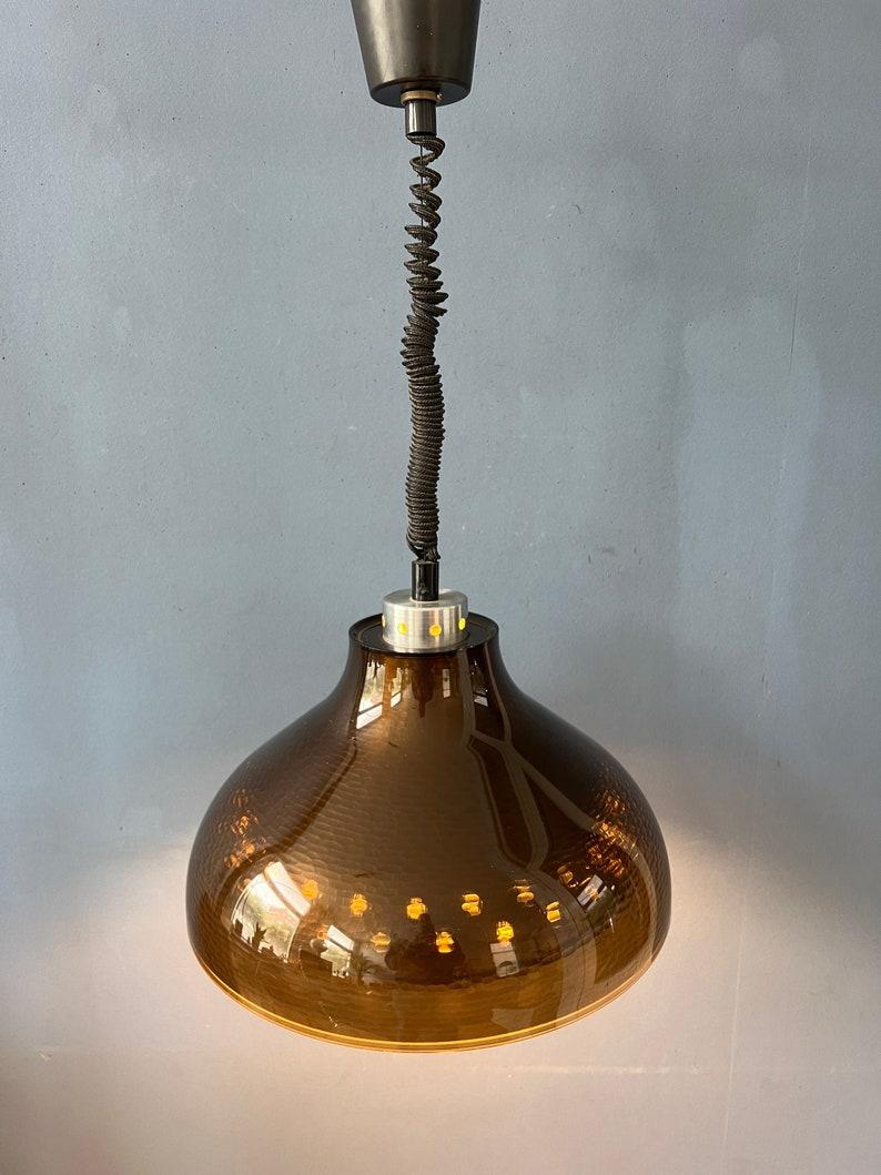 Lampe suspendue UFO en verre acrylique fumé de l'ère spatiale du milieu du siècle dernier. La lampe a un abat-jour extérieur en verre fumé et un abat-jour intérieur en aluminium à motifs. Ensemble, ils créent une magnifique lumière 