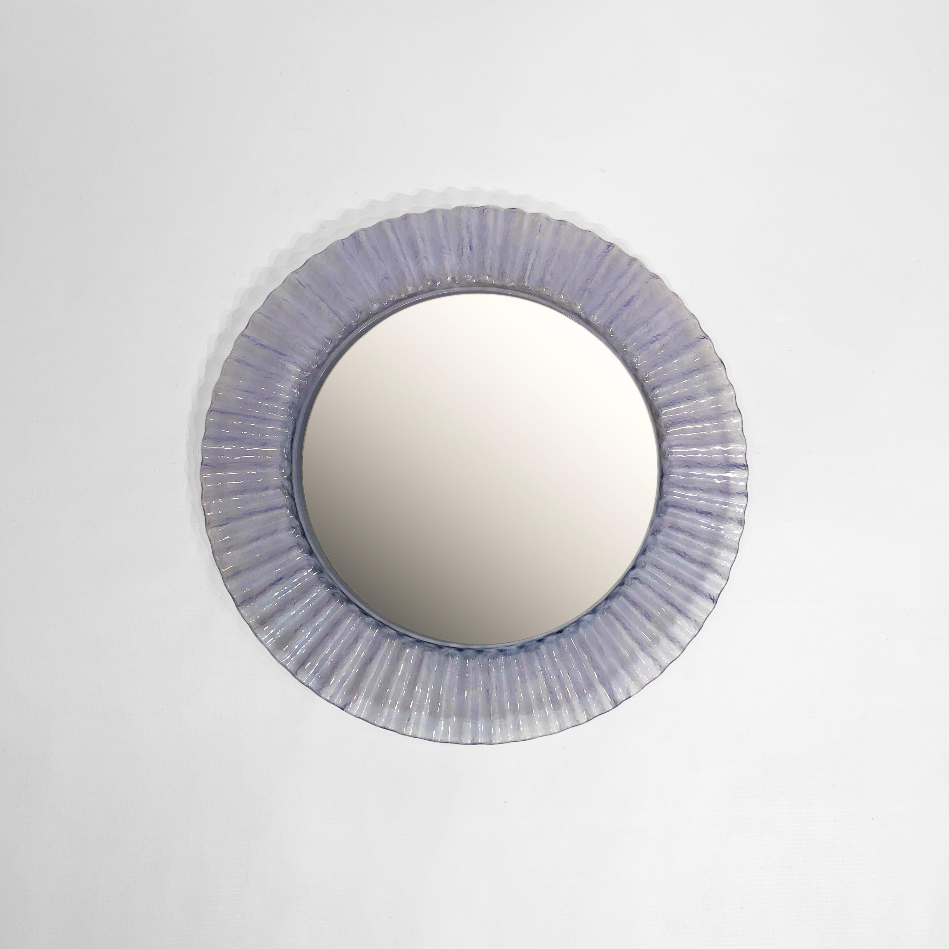 A fantastic 1970s round mirror, with a frame made from crimped acrylic to give the effect of an icy wave. 

The frame of the mirror is crafted from a clear transparent icy blue acrylic giving it a contemporary feel. This frame houses a round pane of