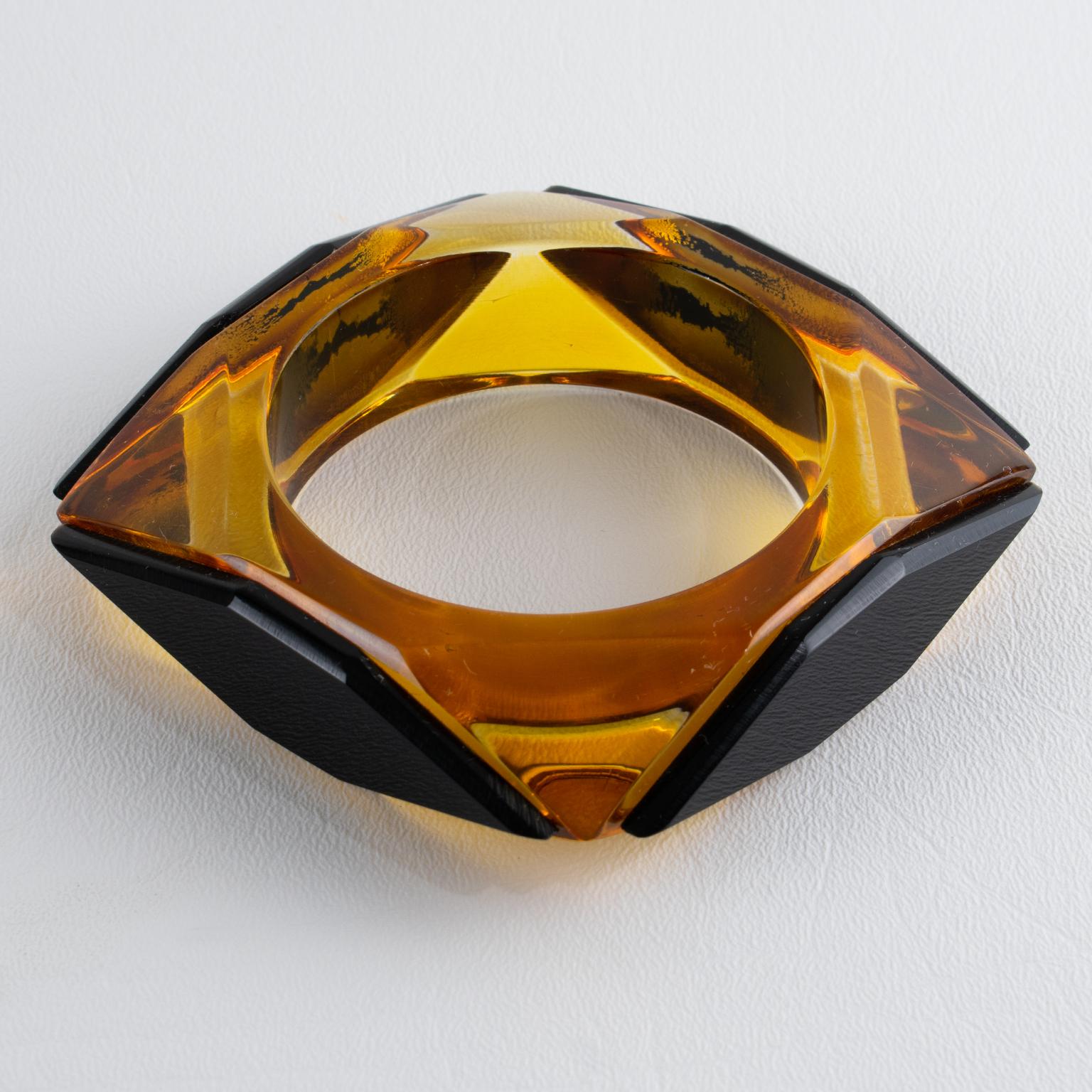This stunning, chunky geometric acrylic Lucite bracelet bangle features a bold, square-carved shape with a contrasting pattern. The bracelet boasts a luminous, transparent apple juice color with black diamond-shaped accents on each side. There is no