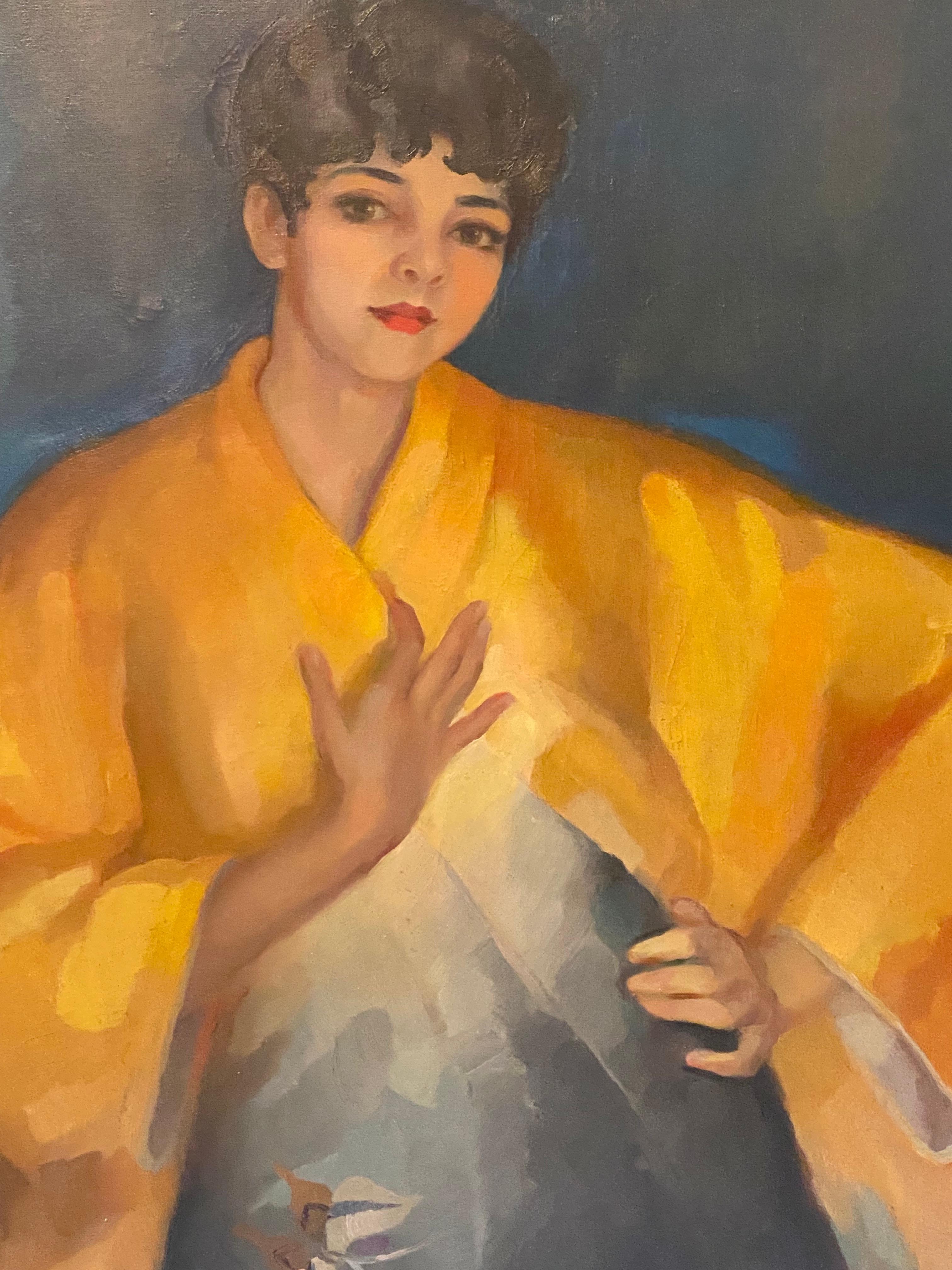 A woman with red lipstick, wrapped in a golden kimono, stands with a slight sway of her hips, her silhouette emerging from a deep, near-abstract background. One hand rests on her chest, while the other is firmly placed at her waist —an attitude that