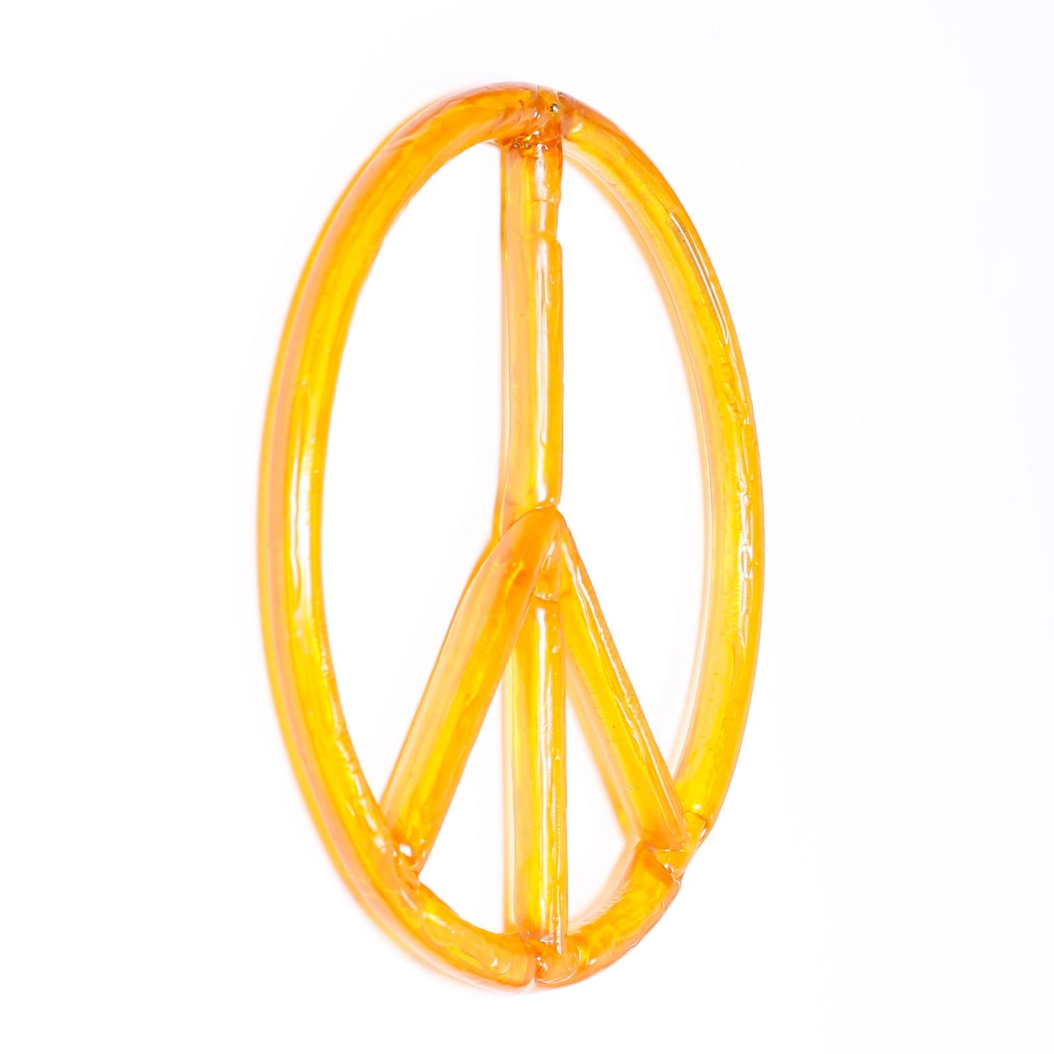 Peace sign handcrafted in molded amber acrylic, standing the test of time as a symbol of our cultural history.