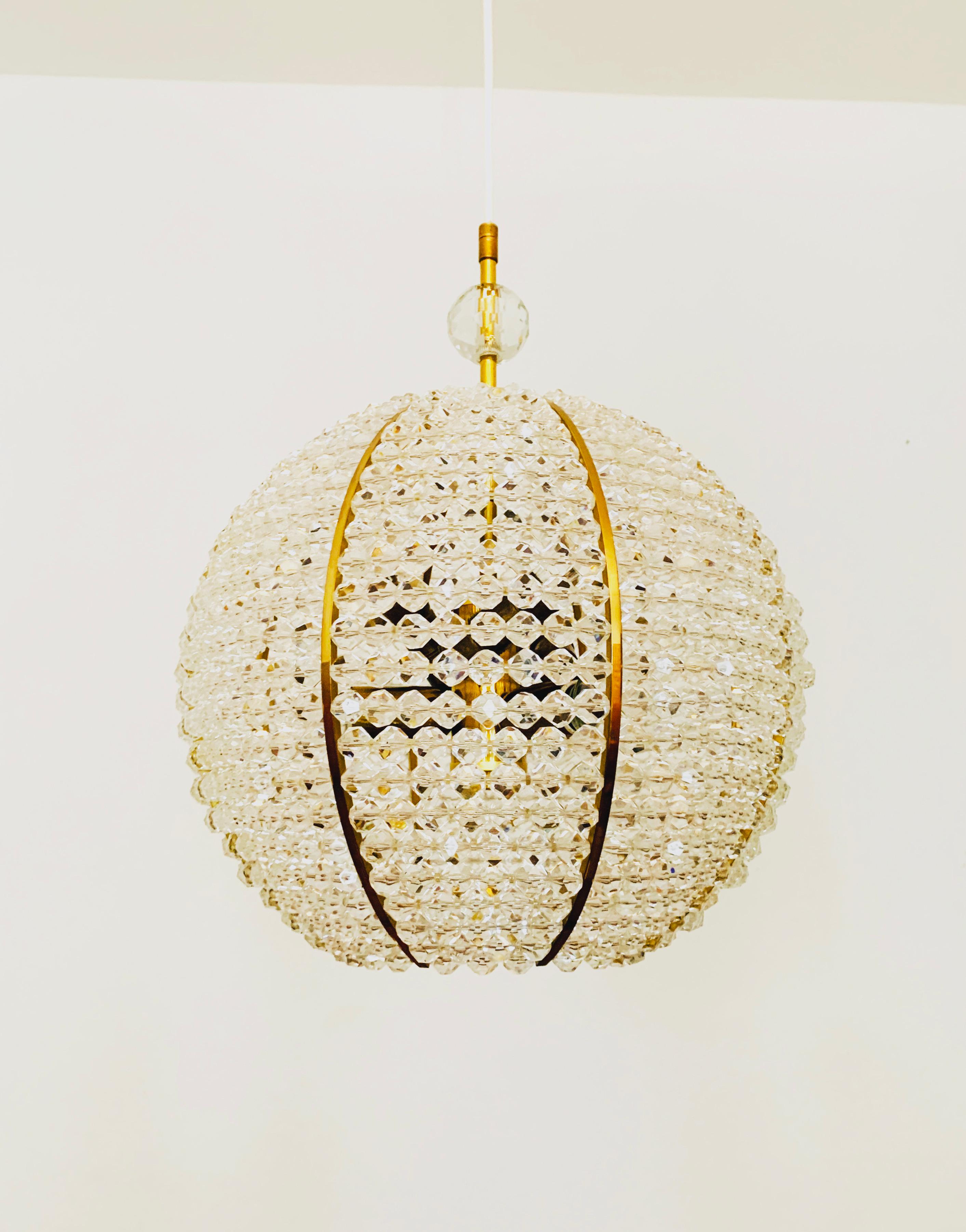 Wonderful spherical lamp from the 1960s.
The lamp with its lavishly equipped plexiglas balls and the brass details has a very luxurious look and sparkles particularly beautifully.
The design and the materials used create a great glittering