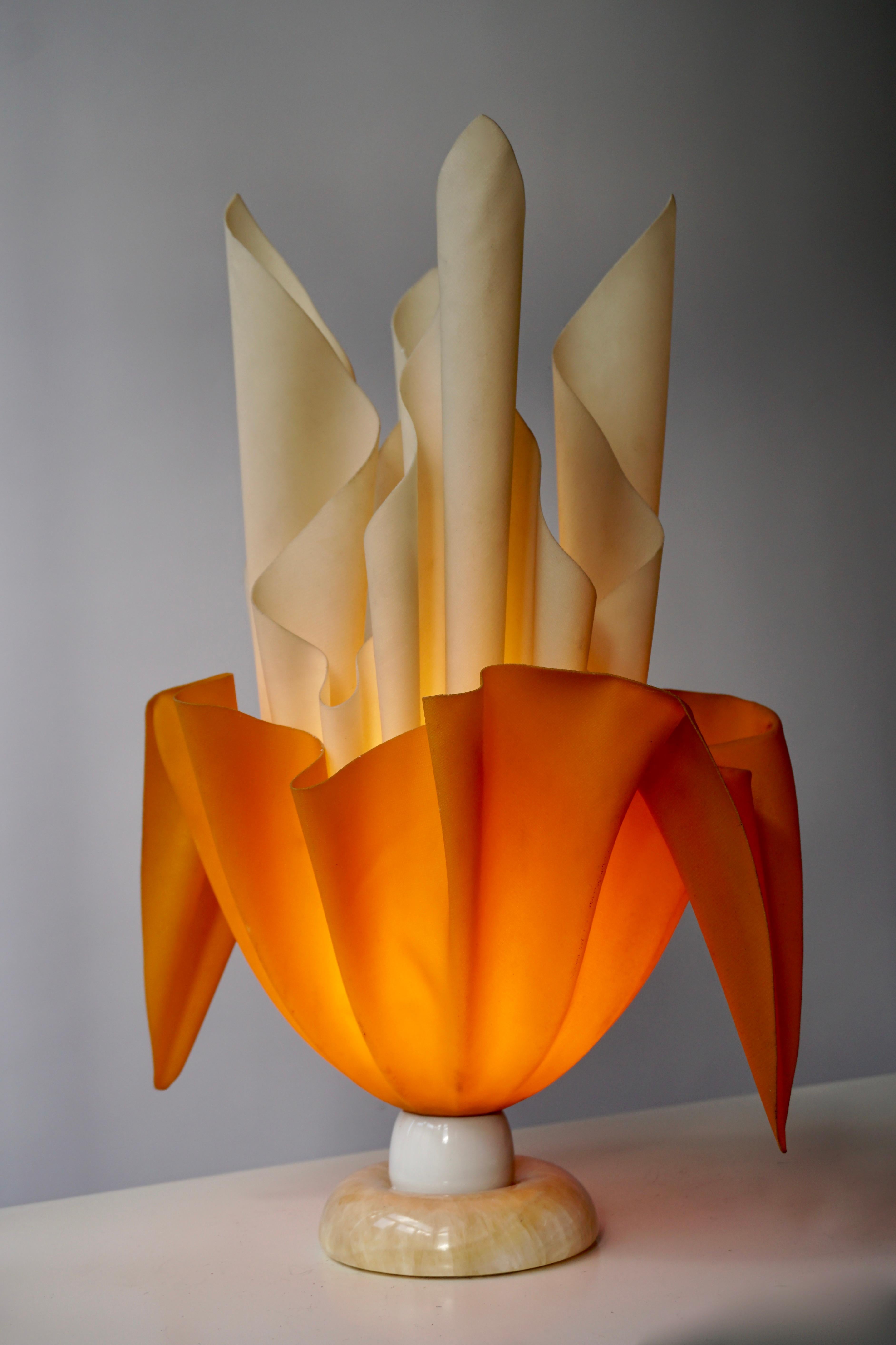 Materials: Round white marble base. Lampshade made of white and orange fabric soaked in some colourless resin or polyester. Dried in a handkerchief or flaming torch style. Plastic E27 socket.

Height: 51 cm / 9.05”
Width: ∅ 35 cm / 5.90”
Depth: 28