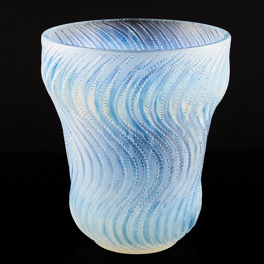 Actinia, an Art Deco opalescent glass vase by René Lalique (1860-1945). Raised, swirling pattern in graduated electric blue opalescence. Etched 'R Lalique France' to underneath.

Photographed on contrasting backgrounds to accurately represent
