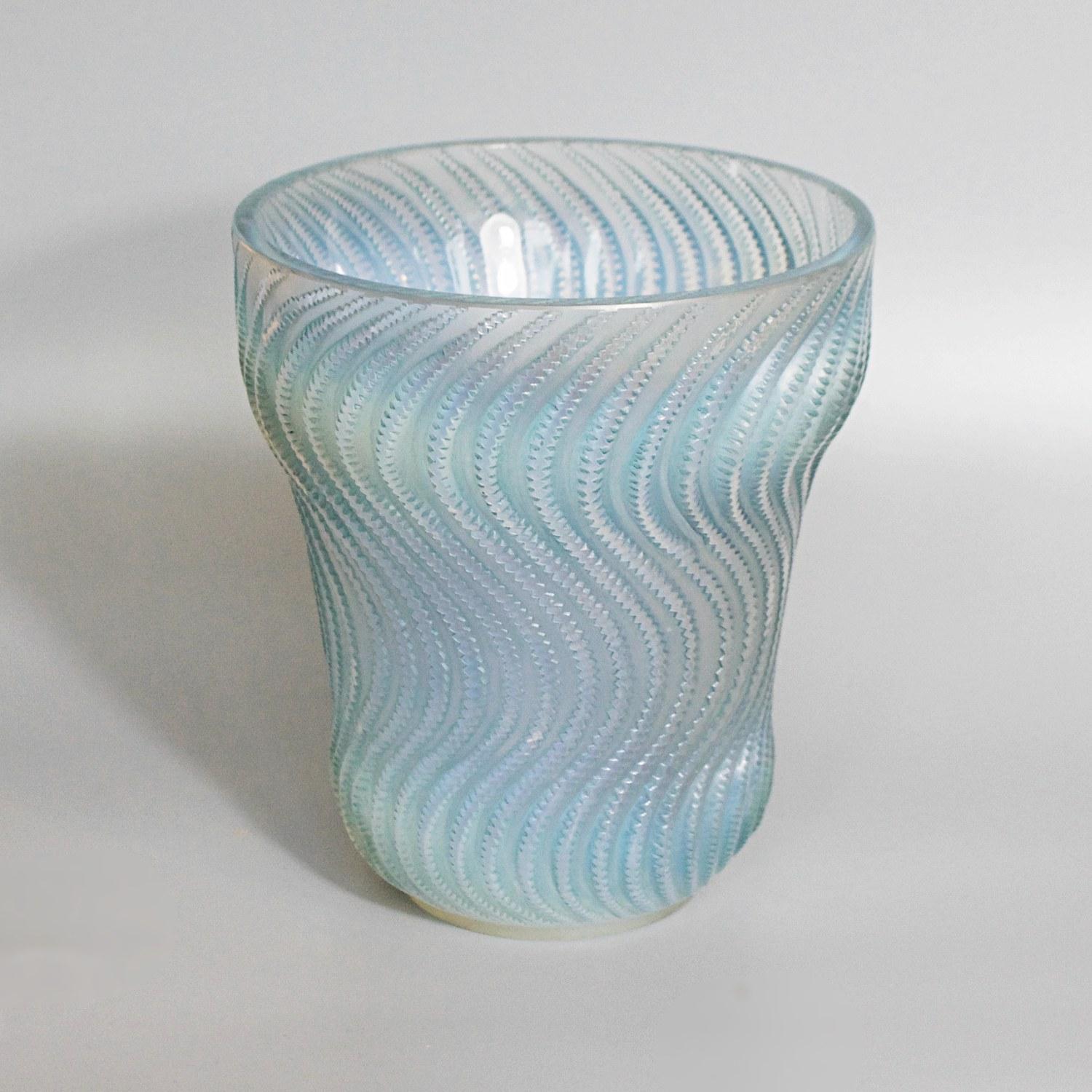 Actinia, an Art Deco opalescent glass vase by René Lalique (1860-1945). Raised, swirling pattern in graduated blue green opalescence, highlighted with original blue/green staining. Etched 'R Lalique France' to underneath.

Stencilled R Lalique to