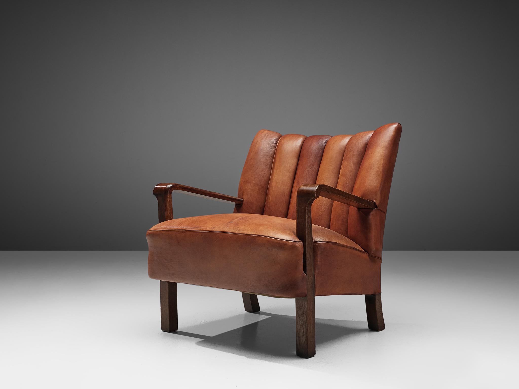 Acton Bjøn for cabinetmaker A.J. Iversen, armchair, Niger leather, patinated oak, Denmark, 1930s.

Early and rare lounge chair by Acton Bjørn in a beautiful cognac colored Niger leather with patinated oak armrest. Warm and inviting piece with a