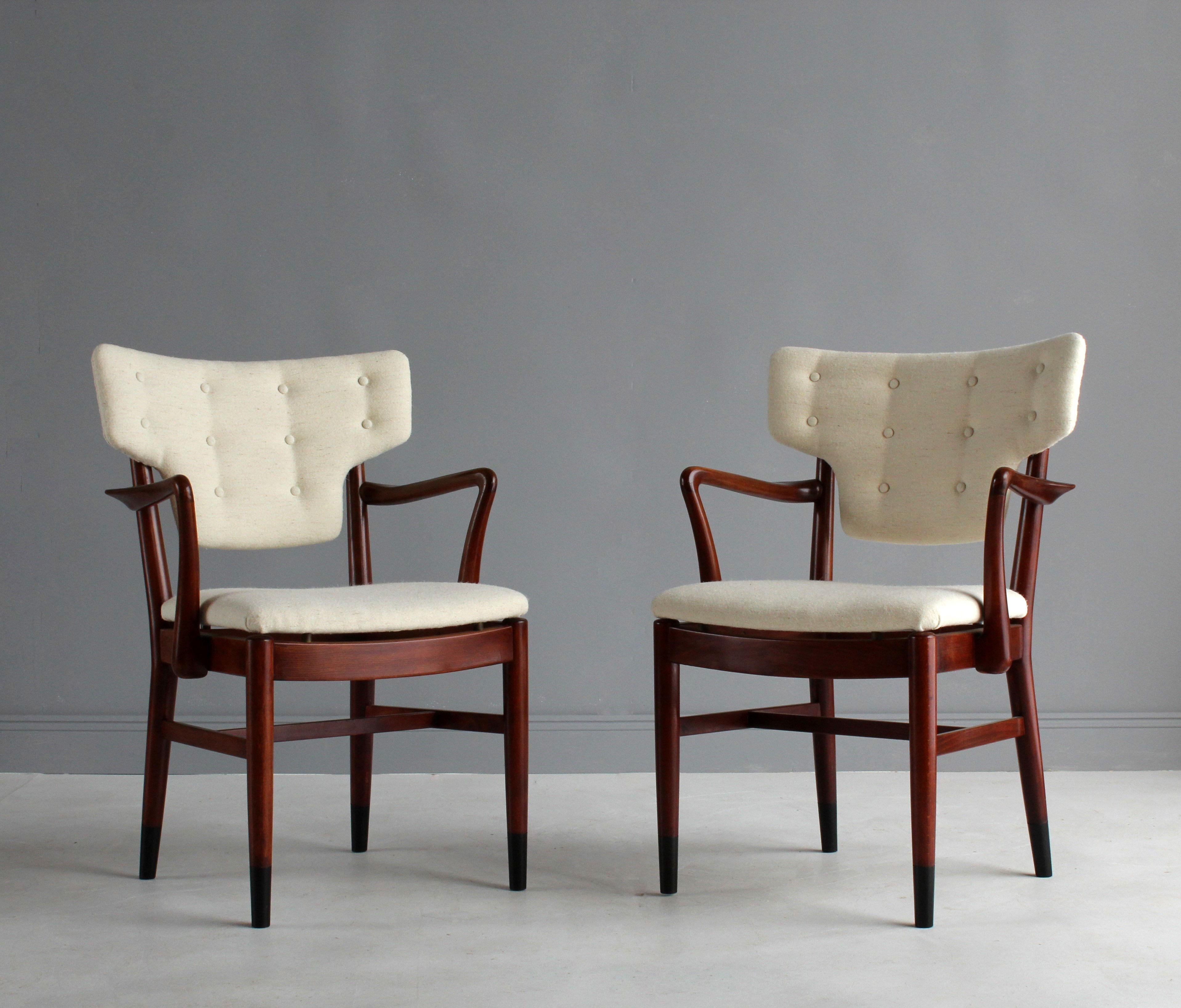 A pair of early modernist side chairs or armchairs attributed to Danish architects Acton Bjørn & Vilhelm Lauritzen, Denmark, 1940s. The frame of superb Danish cabinet-maker quality, in sculpted stained beech, original dark-stained cap feet.