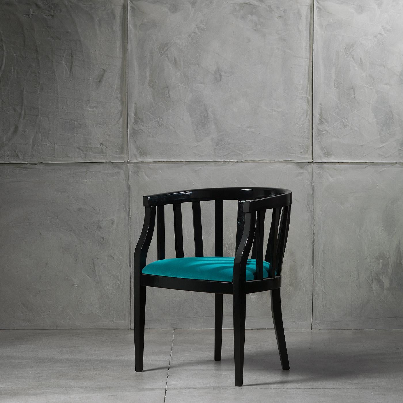 The Ada Chair boasts an enveloping tub silhouette with an elegantly tapered front. Boasting a solid wood frame, characterised by a sleek black finish and stylish slatted detailing, this chair features a padded seat with luxurious velvet upholstery