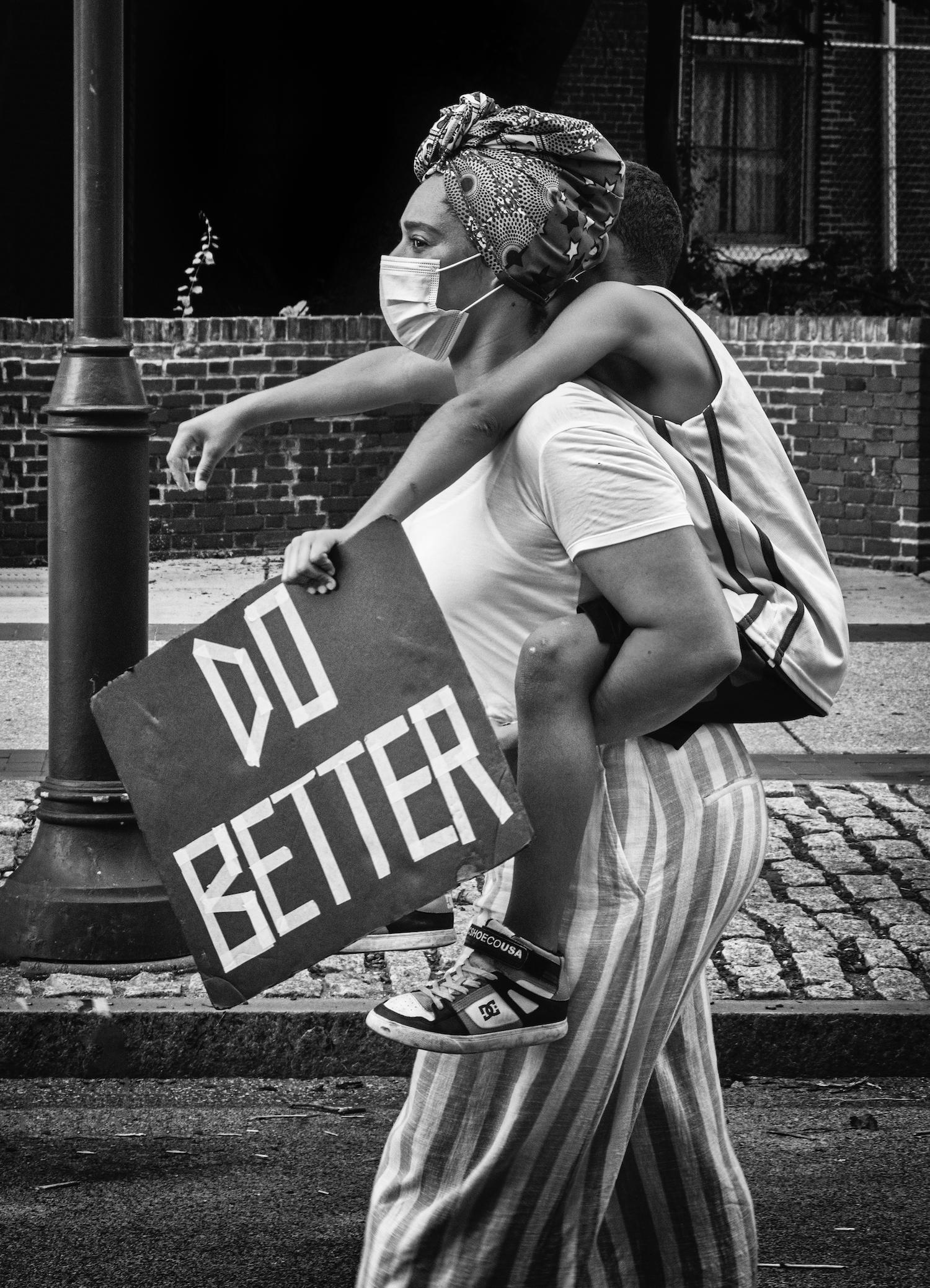 Ada Trillo Figurative Photograph - Do Better: Black Lives Matter city documentary photograph w/ mother & child