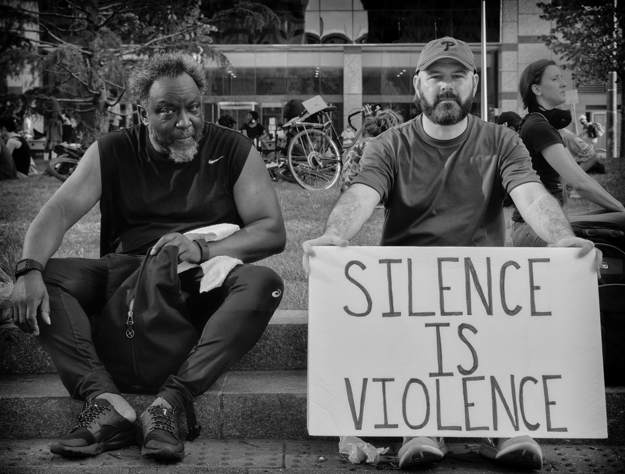 Ada Trillo Black and White Photograph - Silence is Violence: Black Lives Matter city documentary photo w/ 2 men & bikes