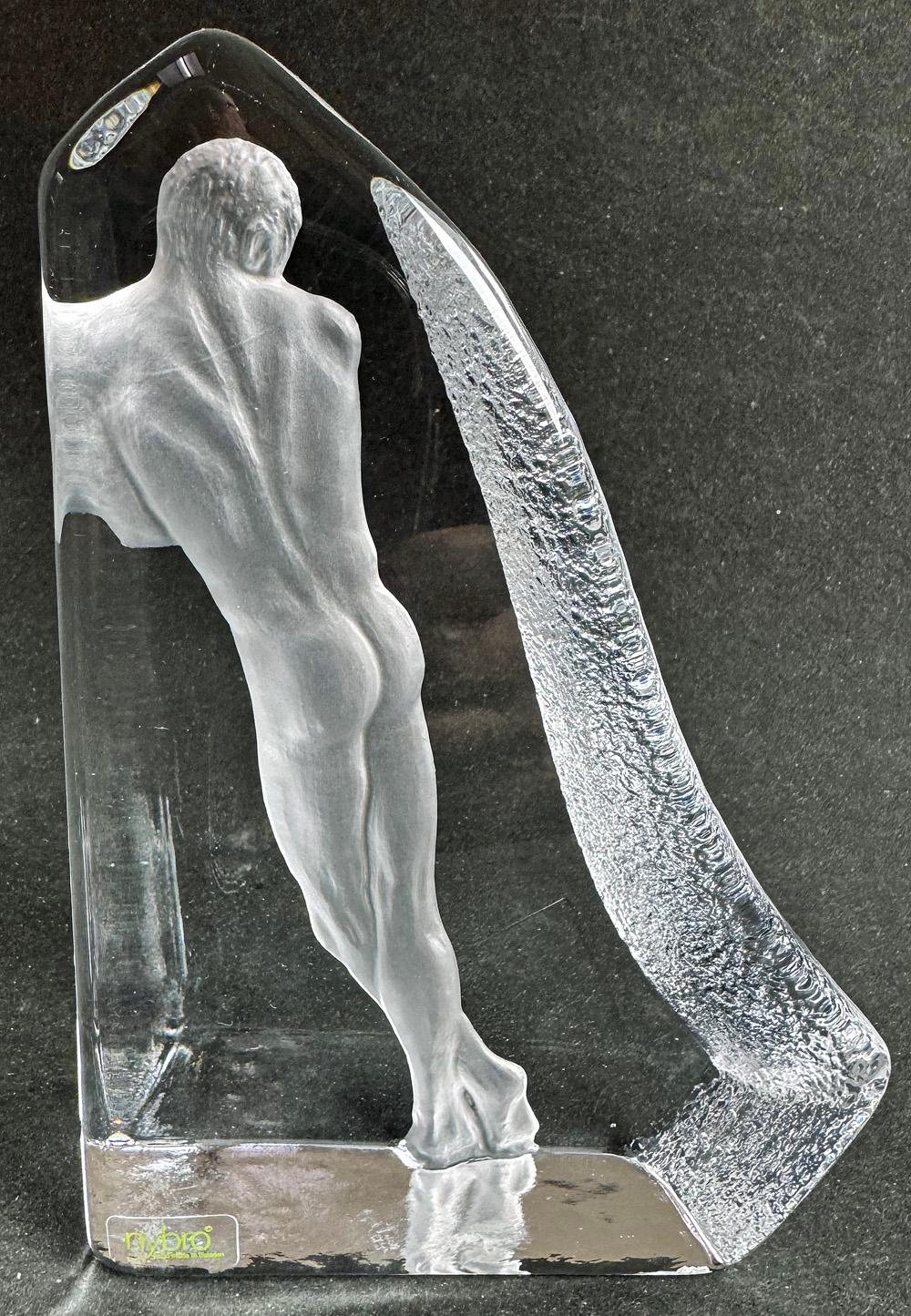 Rara e bellissima, questa scultura in vetro fuso e inciso raffigura la figura nuda di Adams in piedi, profondamente incastonata nel vetro, che si illumina quando la luce passa dall'alto.  Viene mostrato appoggiato alla parete di vetro, con i piedi