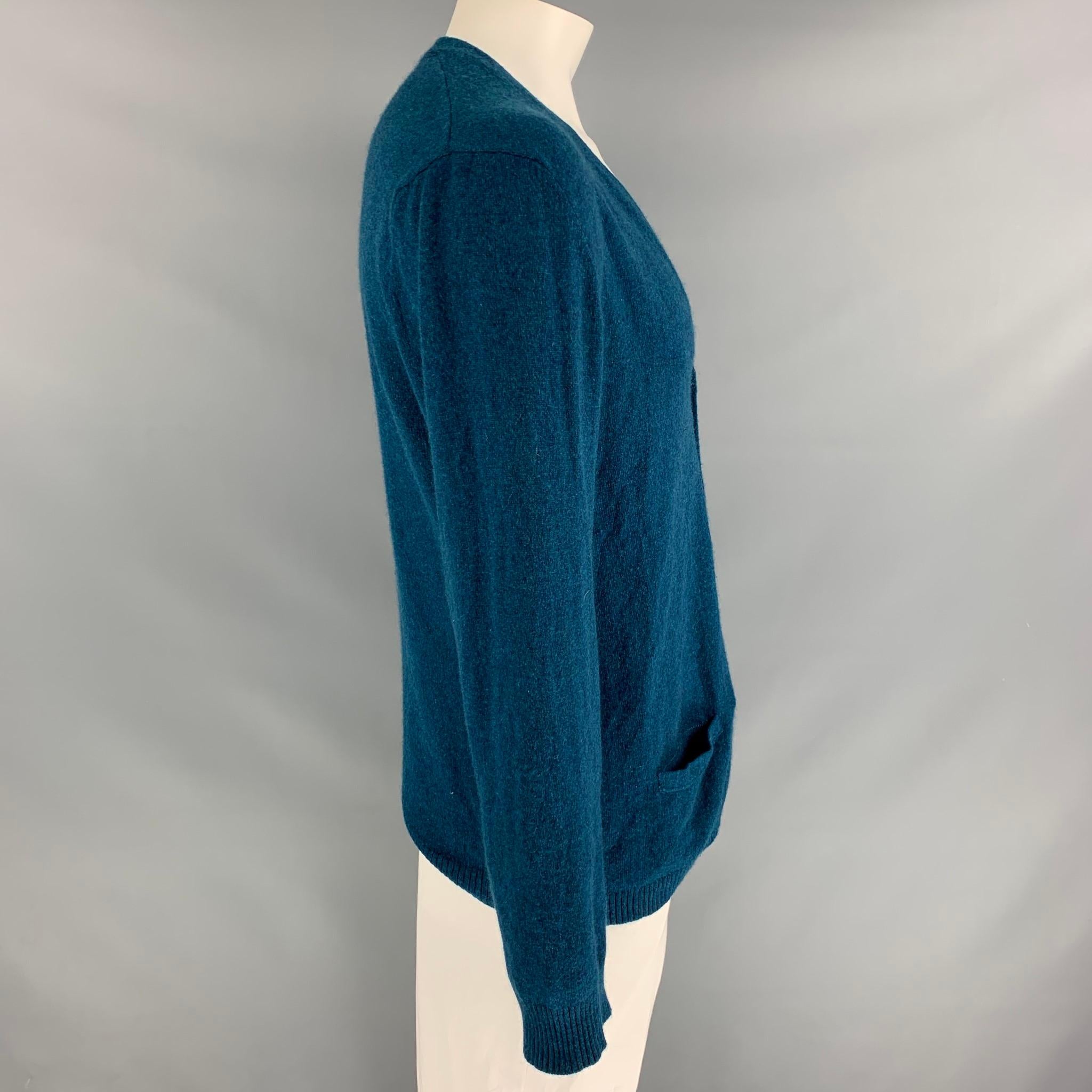 ADAM KIMMEL cardigan comes in a teal cashmere featuring s v-neck, front pockets, and a buttoned closure. 

Very Good Pre-Owned Condition.
Marked: XL

Measurements:

Shoulder: 19.5 in.
Chest: 44 in.
Sleeve: 28 in.
Length: 27 in. 