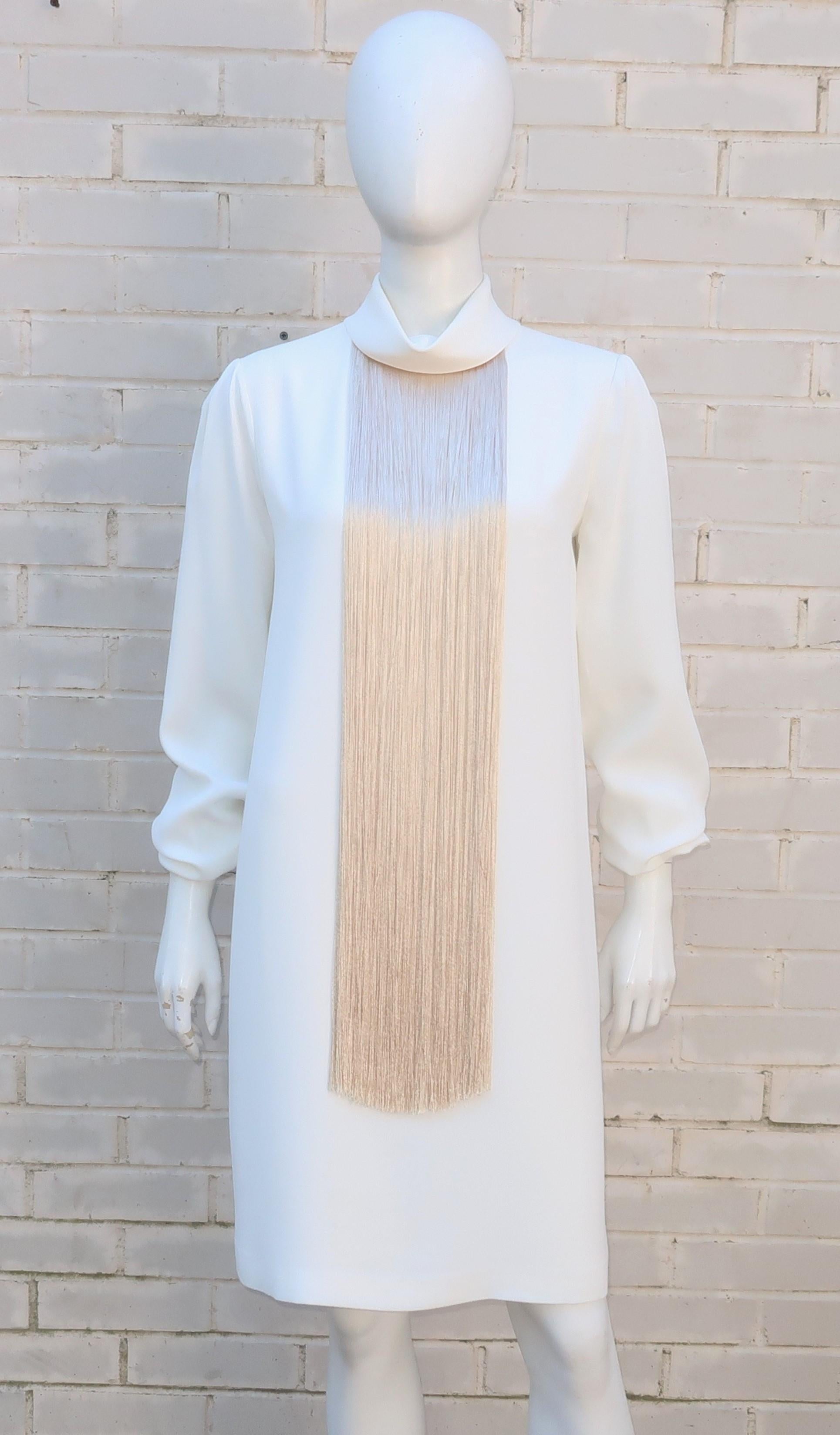Adam Lippes creates a chic ivory cocktail dress with an effortless silhouette accented by a striking long fringe neckline in a golden champagne color.  The dress fabric is a combination of acetate and viscose that has the weight, drape and feel of a
