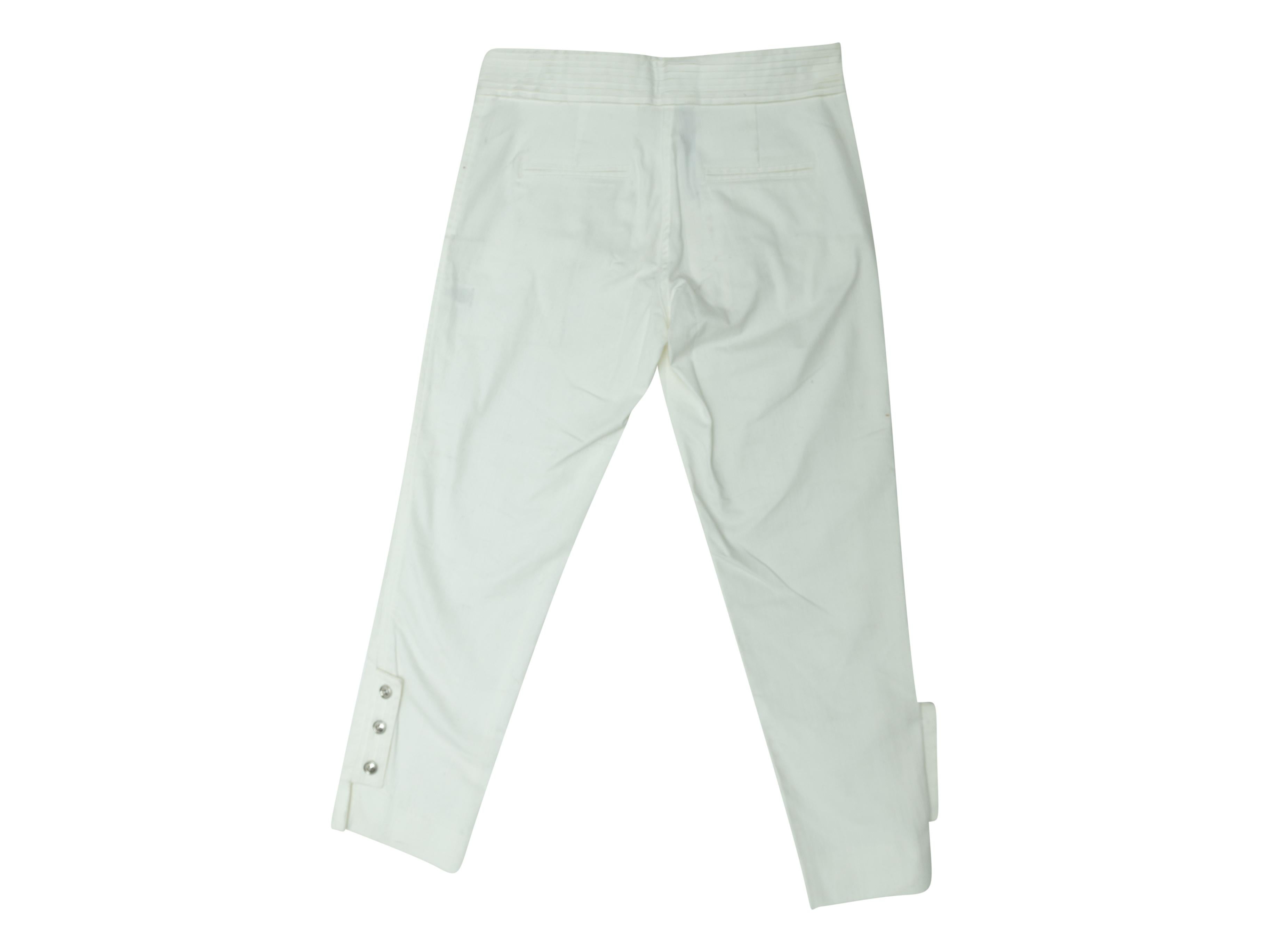 Product details: White straight-leg pants by Adam Lippes. Four pockets. Silver-tone button accents at leg openings. Zip closure at front. 25