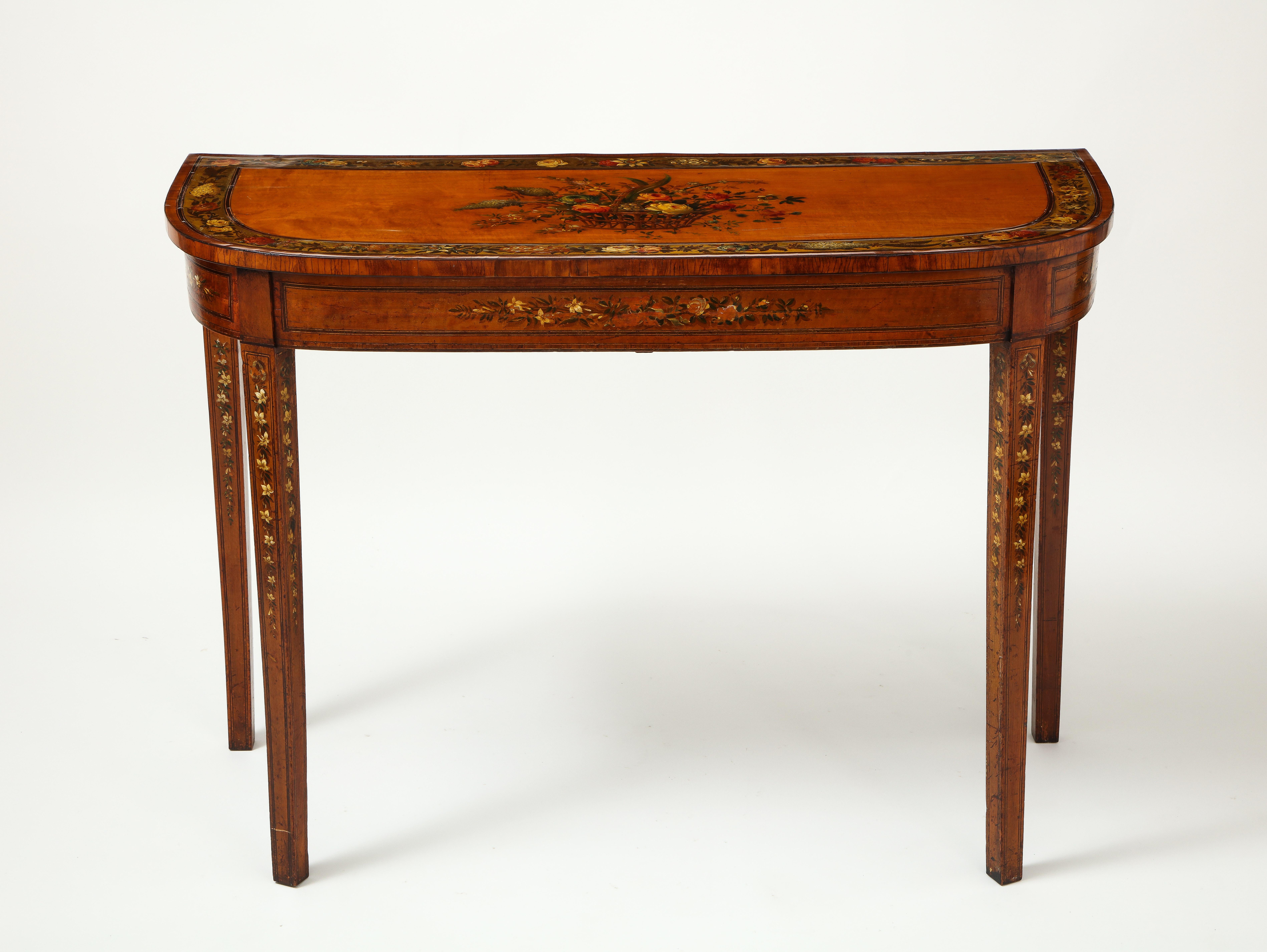 Featuring charming polychrome hand painted decoration of various flowers from the garden.

The top centered by a hand painted basket of flowers including roses, hydrangea, and auricula, with a broad gilt-ground border painted with floral garland;