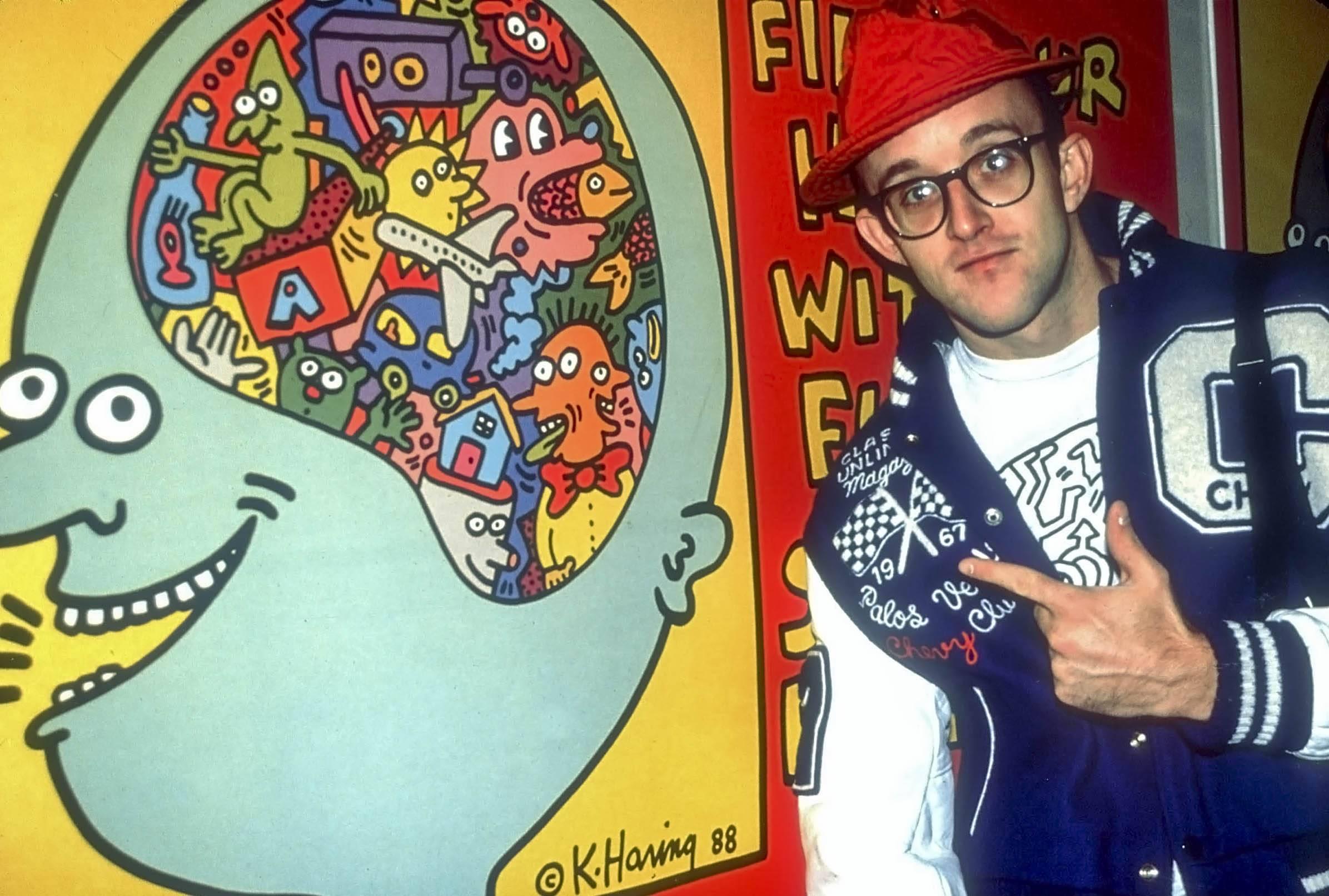 Adam Scull Color Photograph - Keith Haring Pointing to One of His Paintings Fine Art Print