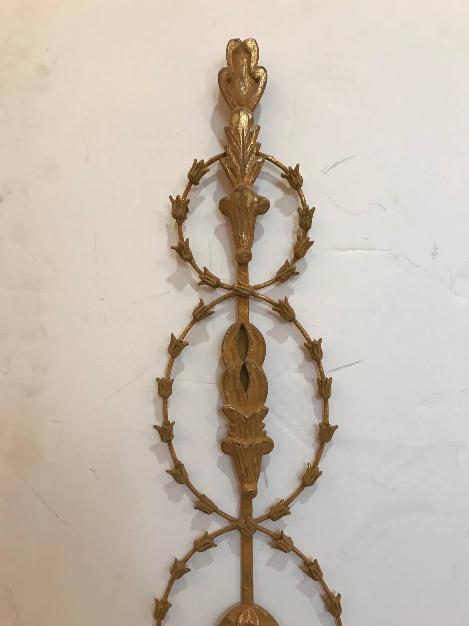Elegant pair of giltwood and metal English Adam style candle sconces. The leafed garlands encircle the center body with two scrolled candle arms with draped garland in between. These are made in Italy but in the English taste.