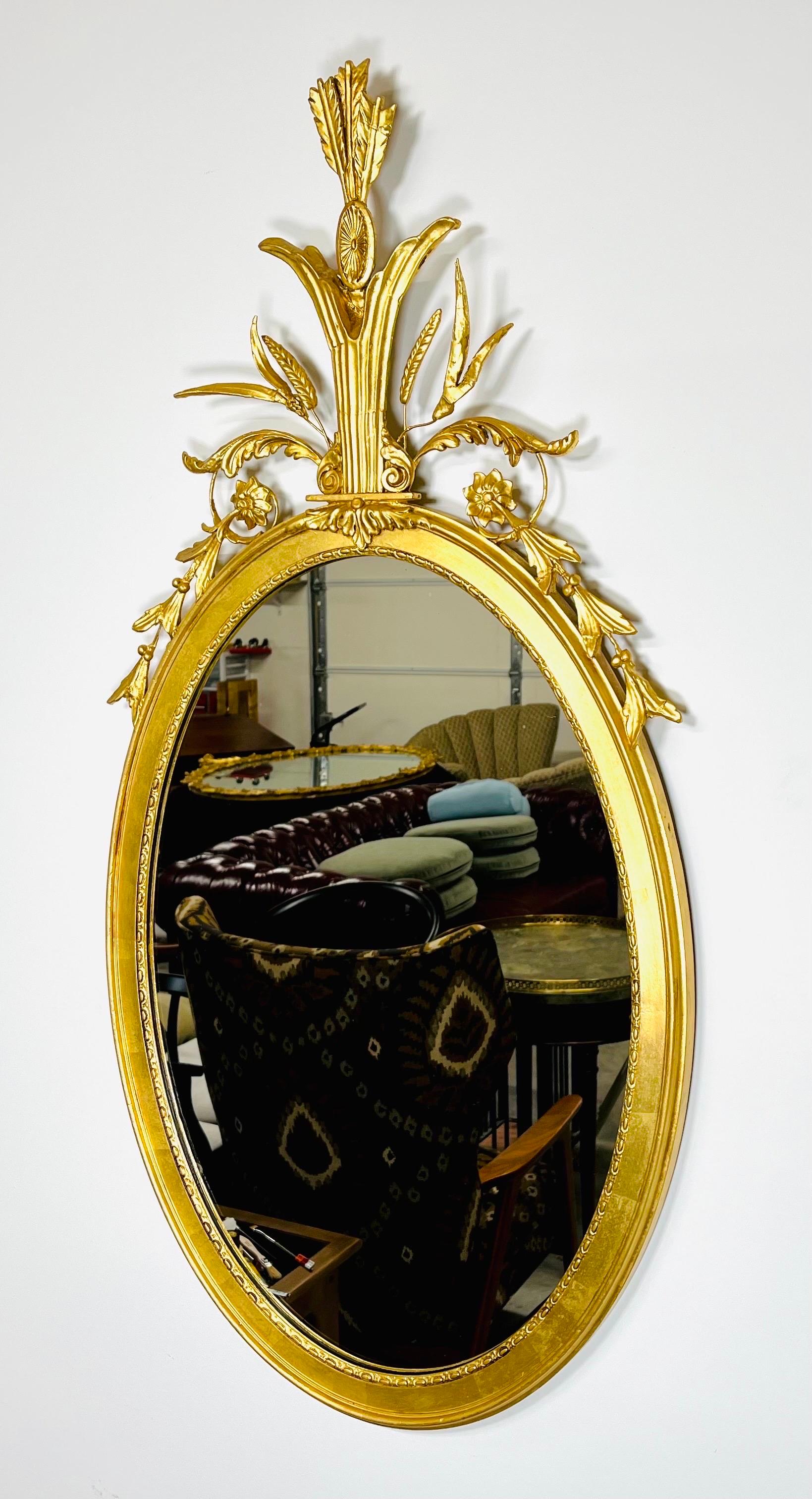 A beautiful Adam’s style mirror adorned with gold gilt wheat sheaf carvings topped with quiver and arrows attributed to Friedman Brothers circa 1940. 
 In outstanding vintage condition having clean, bright gold guilt throughout with a clean mirror