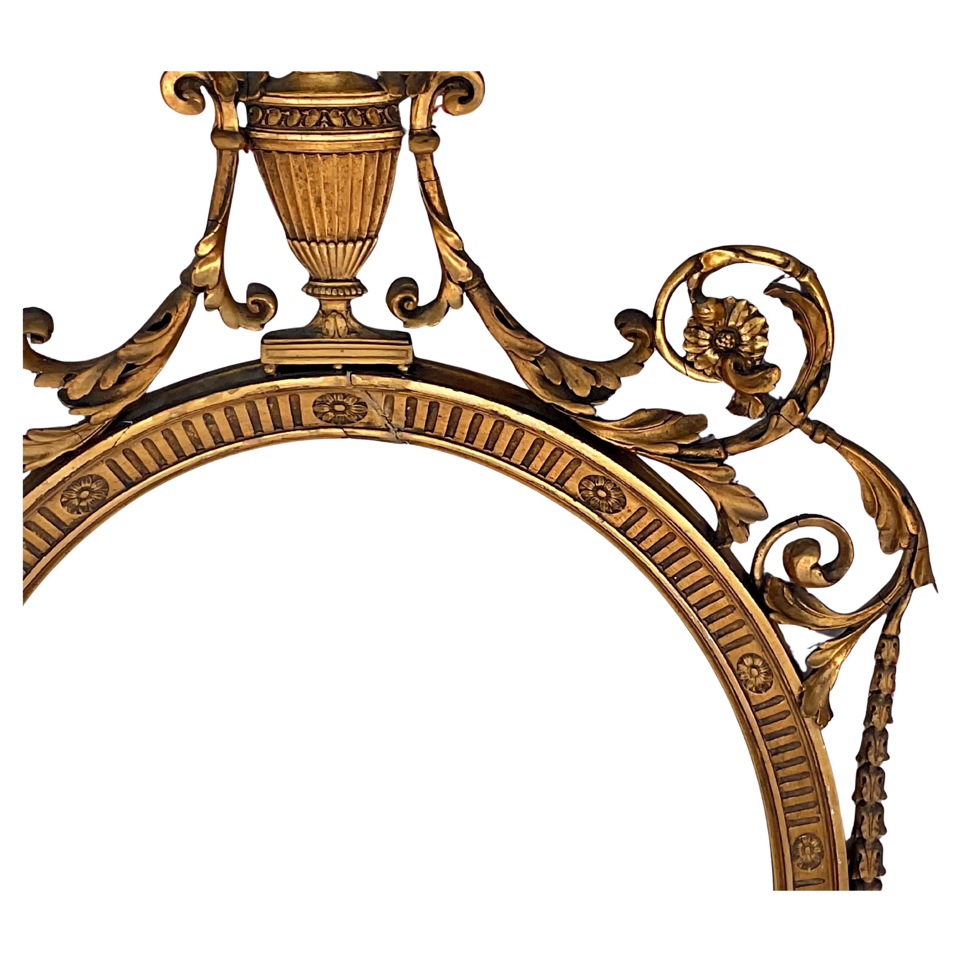 Early 20th Century English Adam Style Oval Gilt Mirror featuring a decorative urn at the crest. 