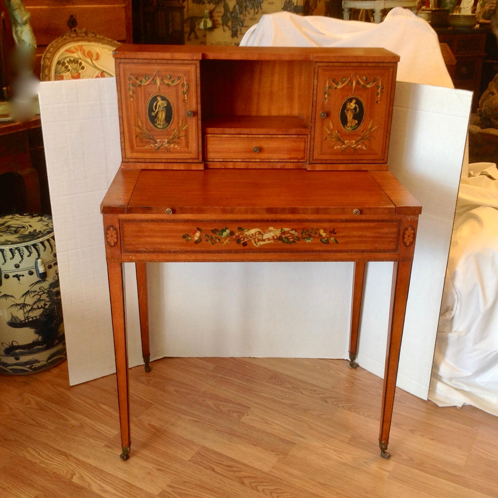 Compact ladies style with a pullout writing surface and storage beneath.
The desk is fashioned with a large side drawer and is appointed with neoclassic 
painted figures in the Adam style. Graceful and functional.
Writing surface is 28