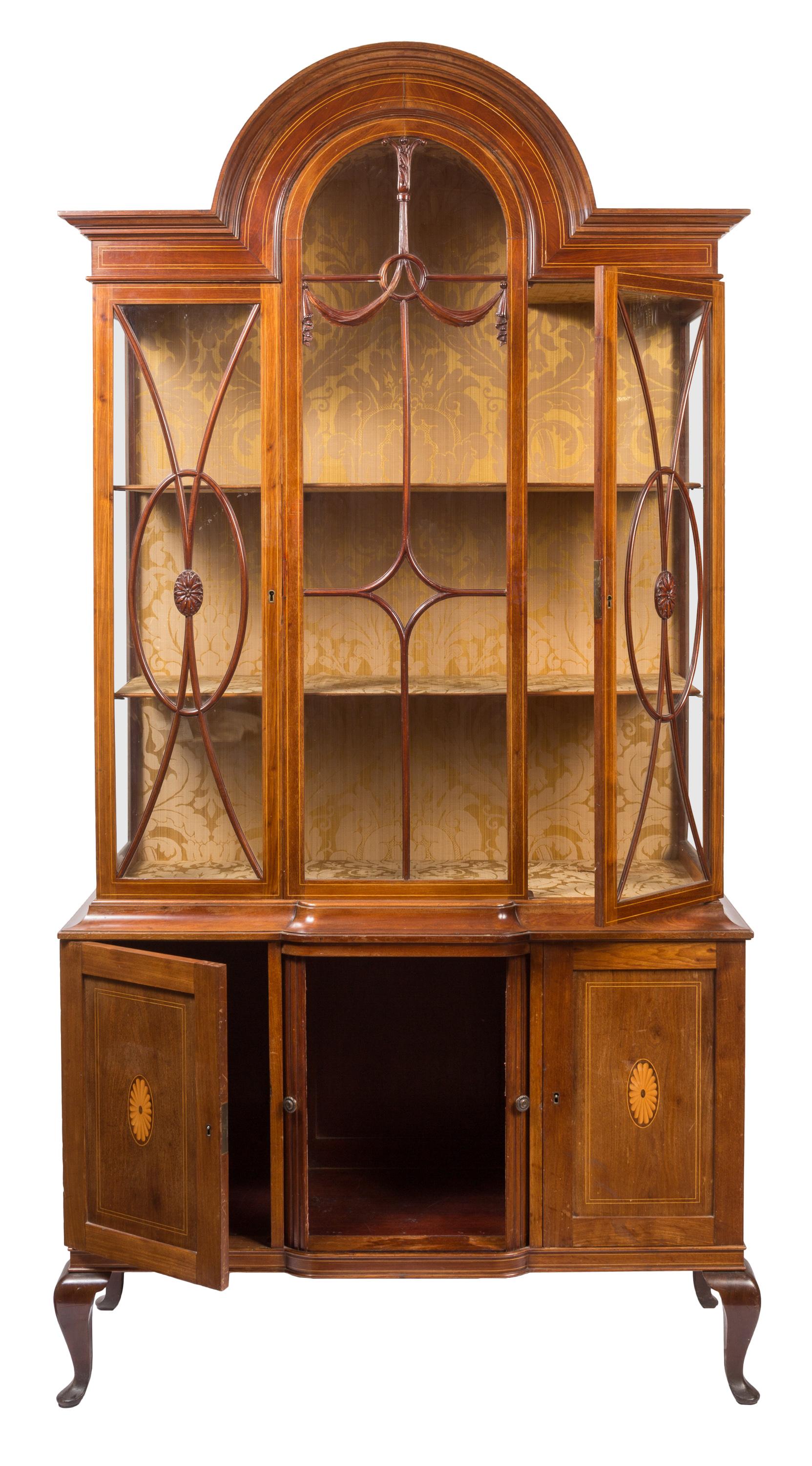 Beautifully architectural in shape and rich in neoclassical details, this 19th century Adam style vitrine / china cabinet has ample glass front display space above, with enclosed storage below, featuring sliding tambour doors at the center. The