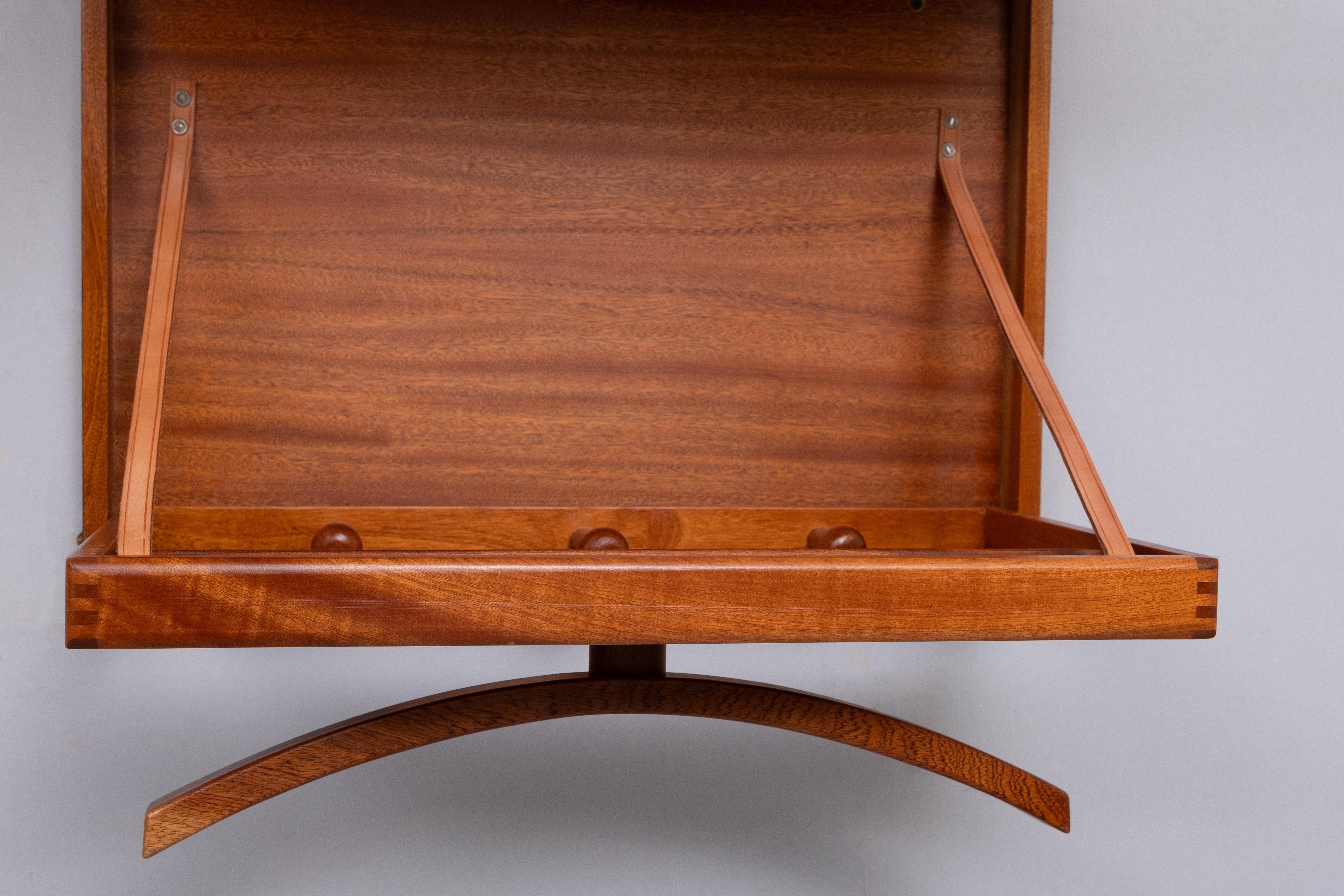 von Hoff & Østergaard pour Virum Møbelsnedkeri  Années 1960 Danemark 
Un objet très cool et rare, il s'agit d'un valet de chambre mural en teck, fabriqué au Danemark dans les années 1960-70. Le design est l'œuvre d'Adams et de Poul Ostergaard, et il
