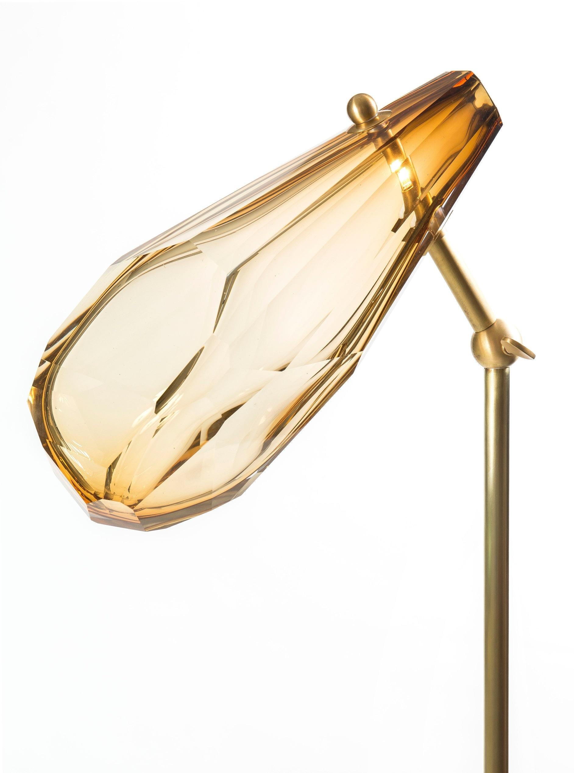 Floor lamp, articulated, made in brushed brass with an amber hand-blown glass. 
The glass is faceted by the hand like a precious stone. The result is each time different and unique. 
Limited edition of 8
Signed and Numbered

Measures: Diameter: