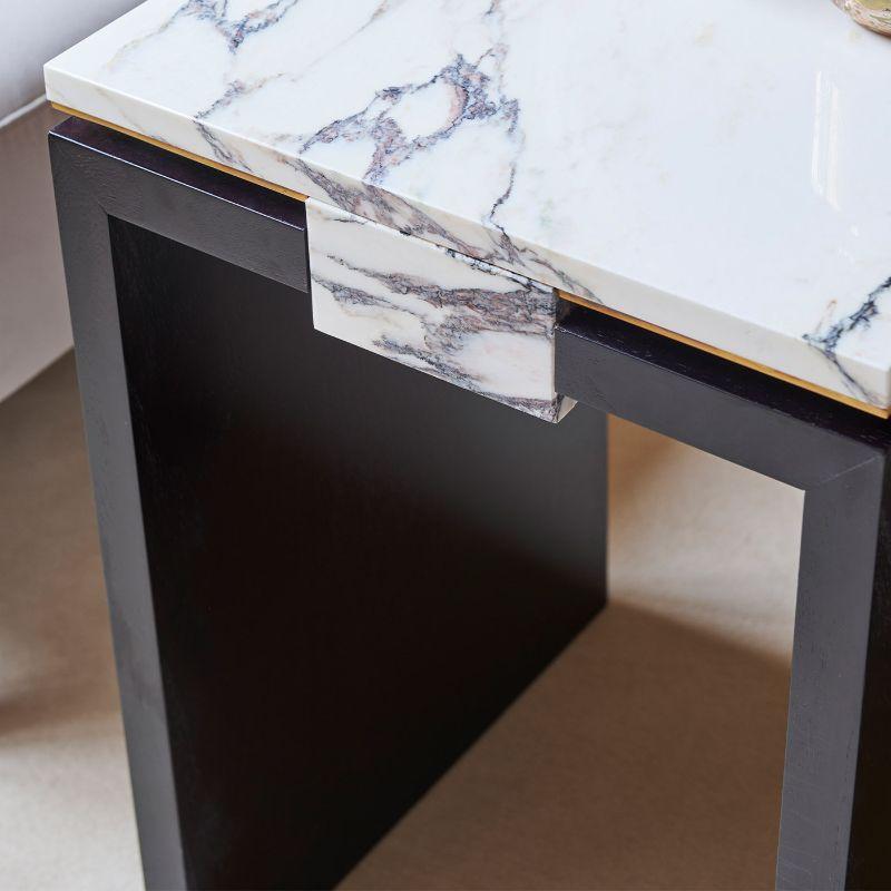A rectangular bedside table in ebonized varnished walnut, central element covered in marble Breccia Medicea, top in marble Breccia Medicea with perimeter wire in brass. Designed by Atelier Avanzi.
 