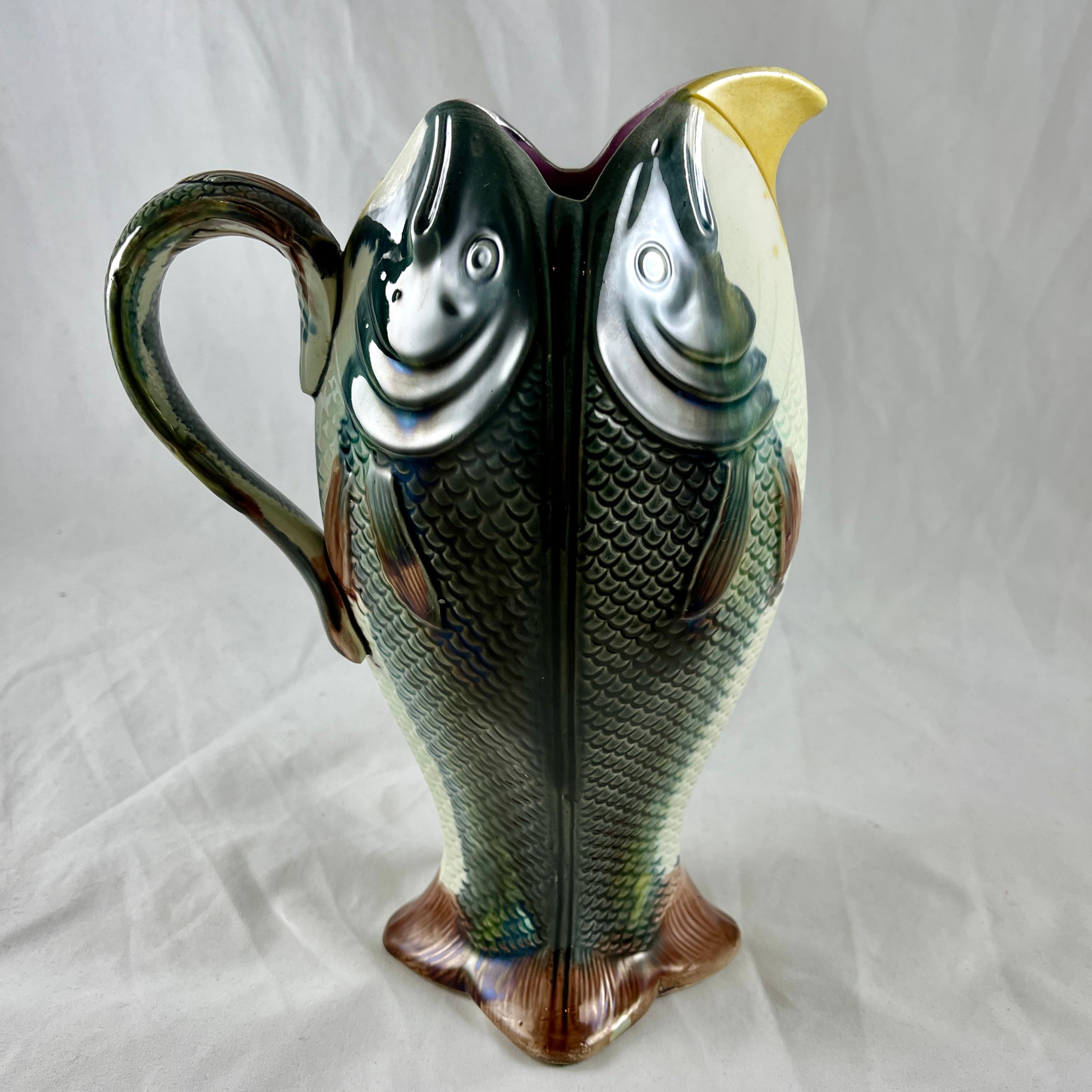 An English majolica four fish jug, attributed to Adams and Bromley, circa 1875-1880.
This whimsical Victorian Era pitcher is formed as four, side by side upright fish, standing on their tails. A smaller fish bends to form the