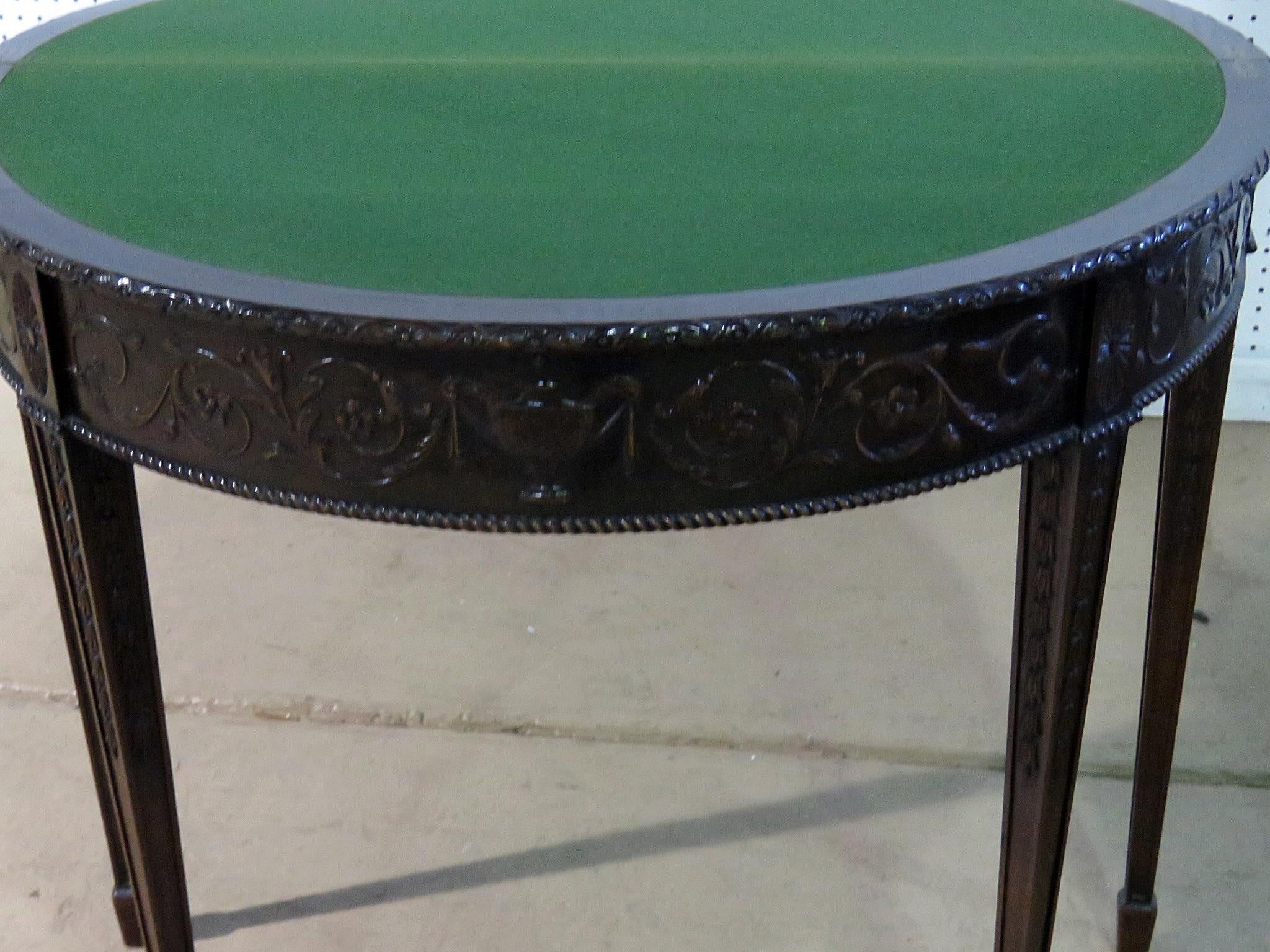 This is a superbly carved solid mahogany Adams style flip top distressed finished game table with carved urn and floral carved details. The table can also of course be used as a console or sofa table. Measures: 31.5