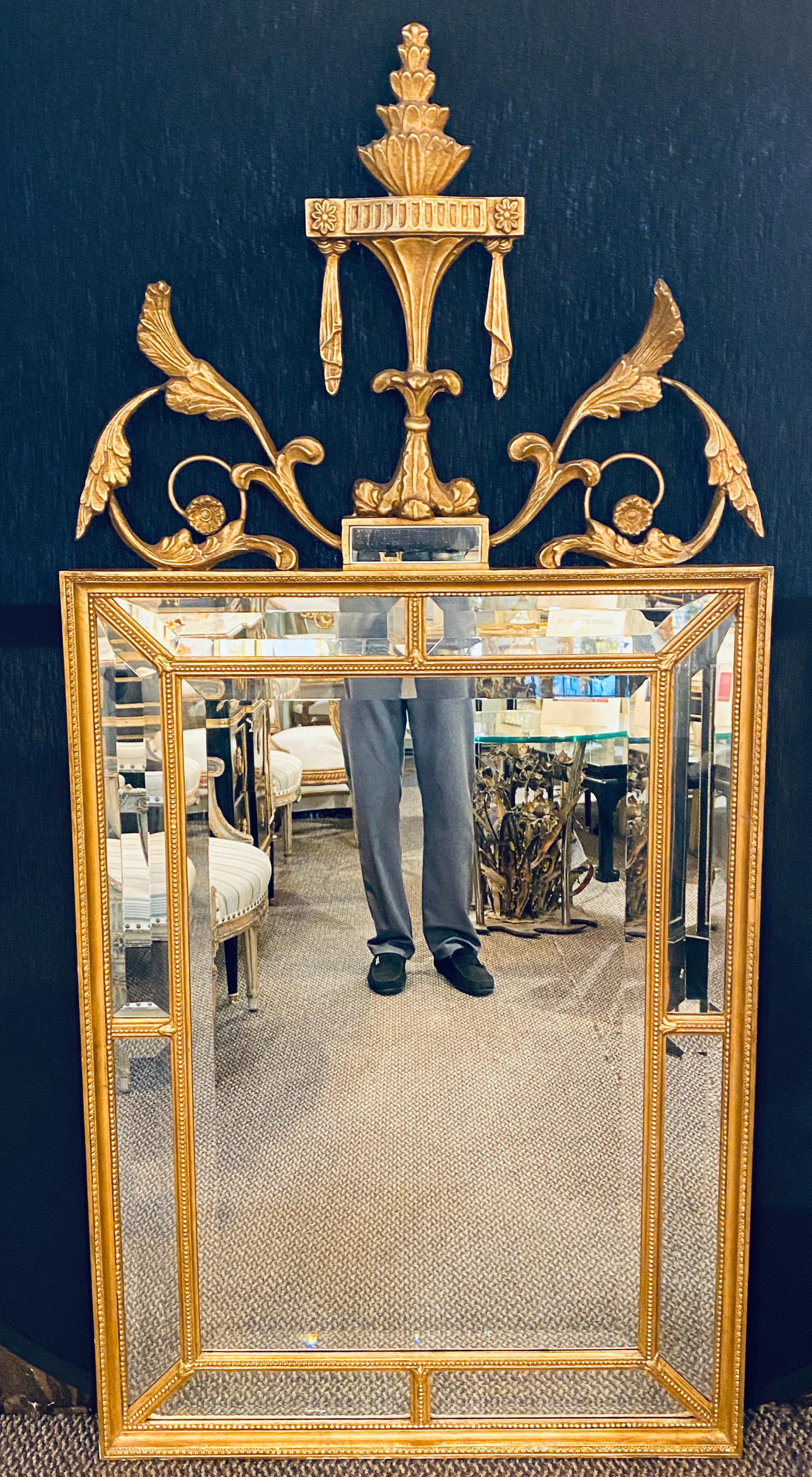 Adams style gilt carved wall mirror with all beveled inserts. This large and impressive wall or console mirror is simply stunning. The center beveled mirror framed by a set of smaller rectangular beveled mirrors all framed in a gilt wood finish.