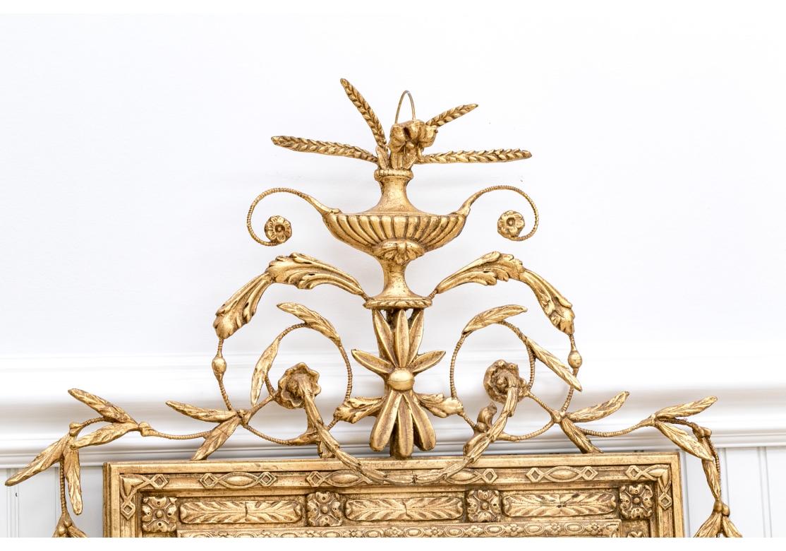 A large, elegant and very well made Gilt wood and metal wire Mirror from the Federalist. The elaborate decoration showcases an urn and leafy crown motif encased in a gilt frame. 

Condition: Please see detail photos. Various minor age related wear